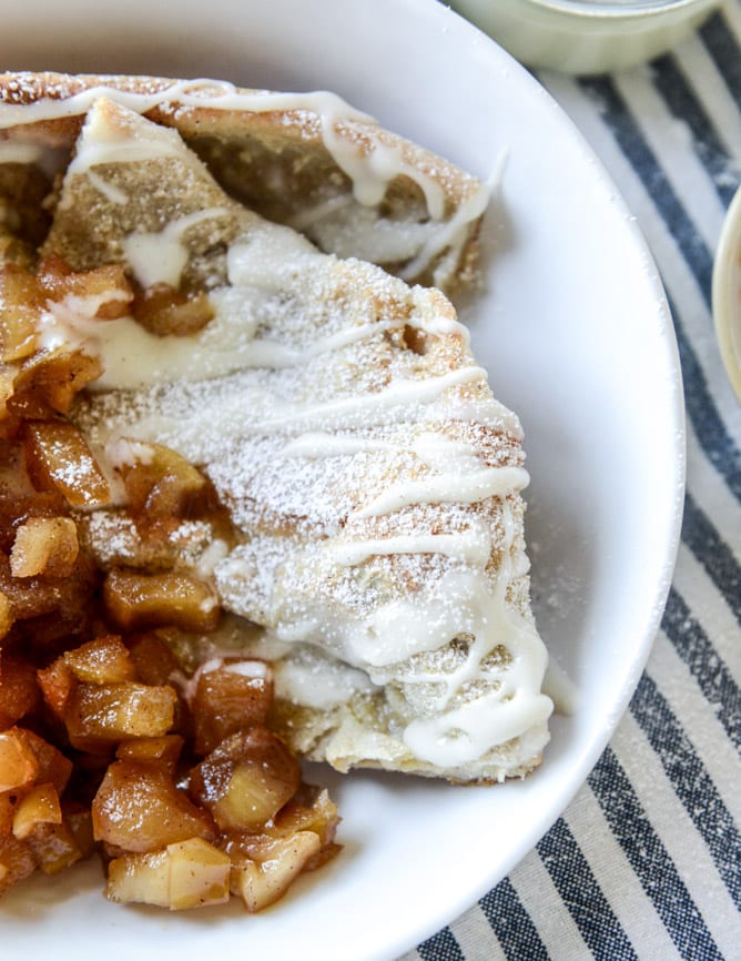 vanilla cinnamon roll dutch baby with apple bourbon compote and cream cheese icing I howsweeteats.com