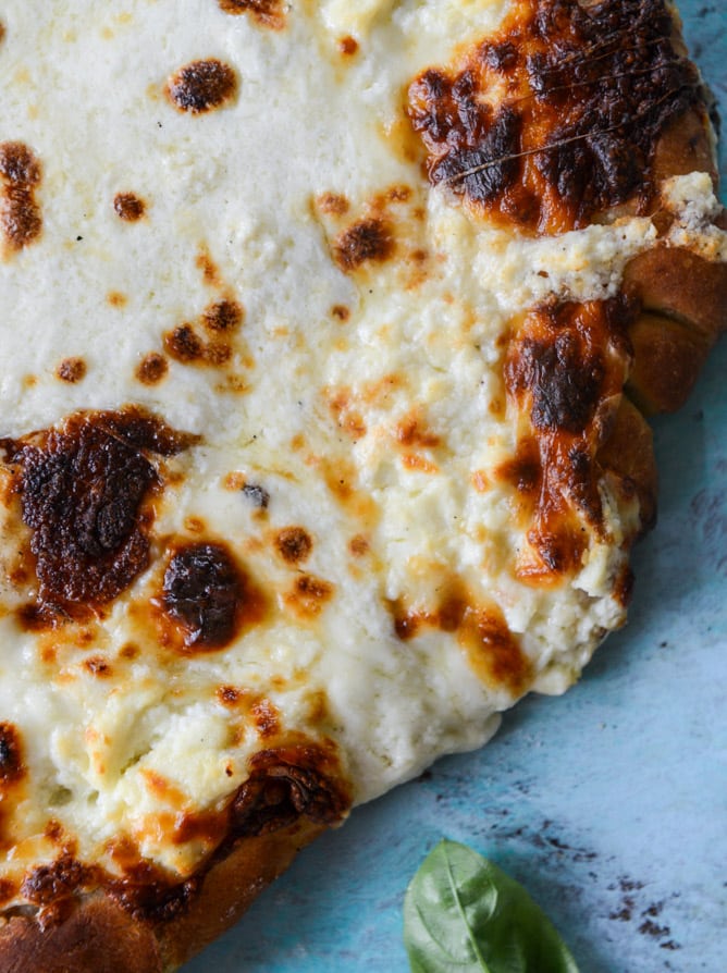 white pizza with garlic sauce and garden herbs I howsweeteats.com