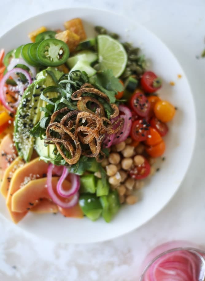 This spicy rainbow salad is chock full of gorgeous, fresh produces, chickpeas, plantains and herbs for one beautiful sight in a bowl. The rainbow salad is satisfying, filling, delicious with a touch of sweet and slightly spicy - everything you want in a meal! I howsweeteats.com #spicy #rainbow #salad