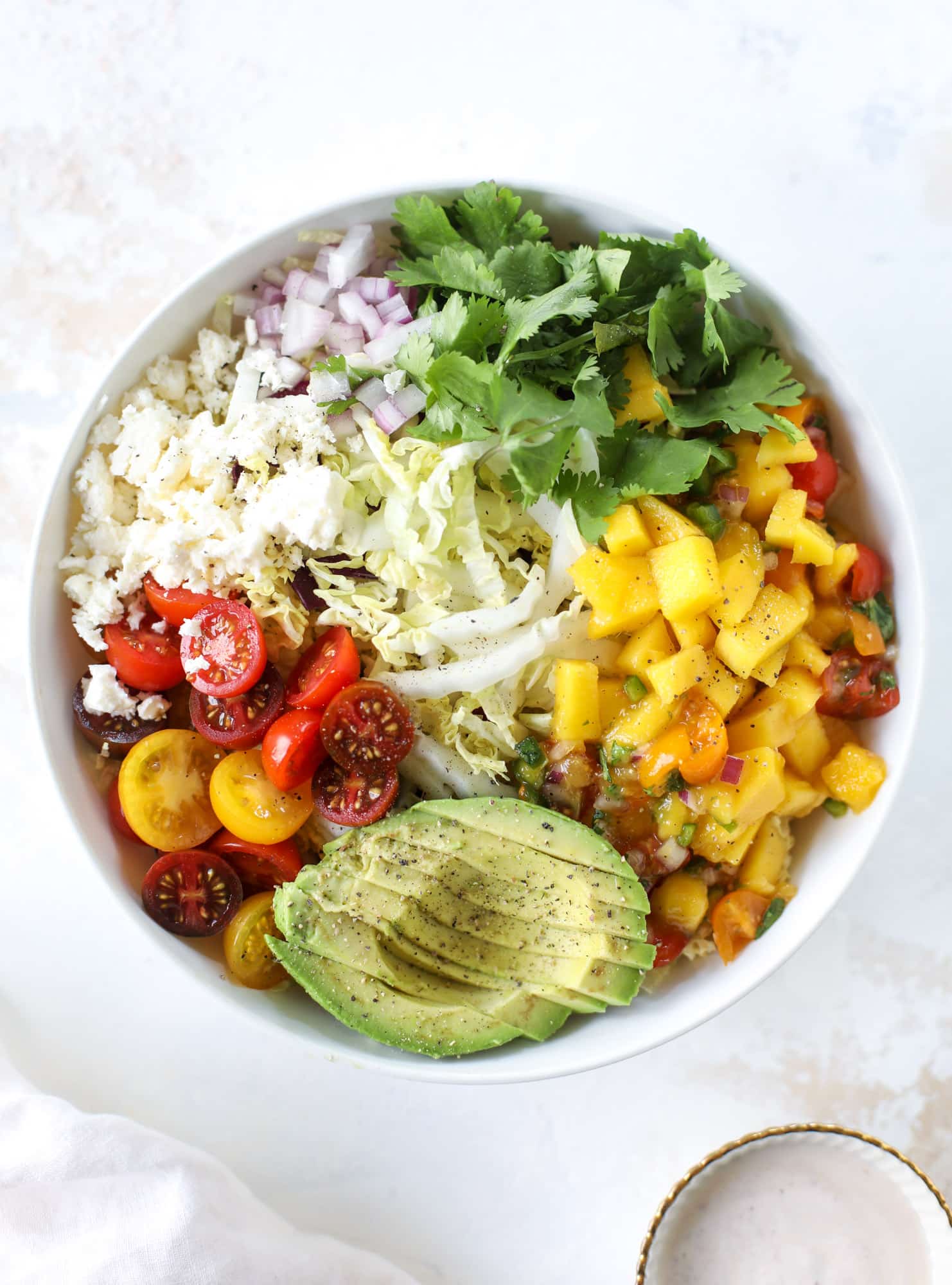 These fish taco bowls are an amazing weeknight meal idea! Napa cabbage for the base, a homemade chipotle crema, avocado, mango pico de gallo, spicy broiled white fish and lots of lime. Major flavor explosion and so easy too! I howsweeteats.com #fish #taco #bowls #spicy #healthy #dinner