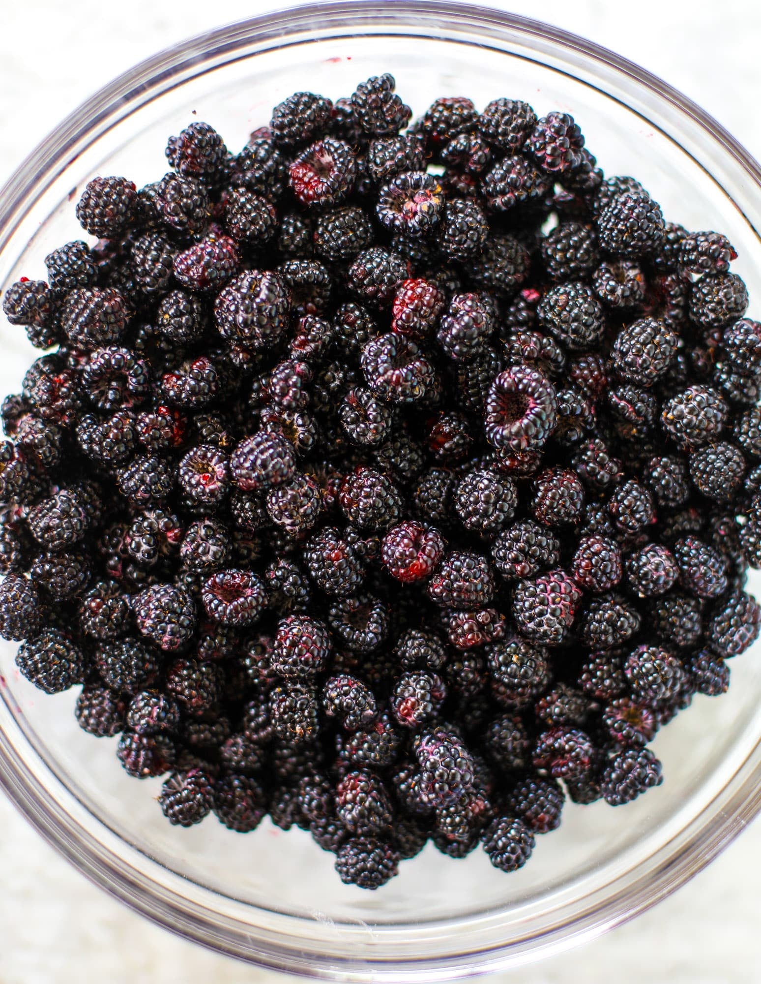 This black raspberry cobbler is a summer dream come true! The bursting black raspberries are rich and sweet, then add in a touch of lavender for incredible flavor and you're all set. The cobbler cake topping is perfect for vanilla ice cream. Win! I howsweeteats.com #black #raspberry #cobbler #lavender #summer #desserts #icecream