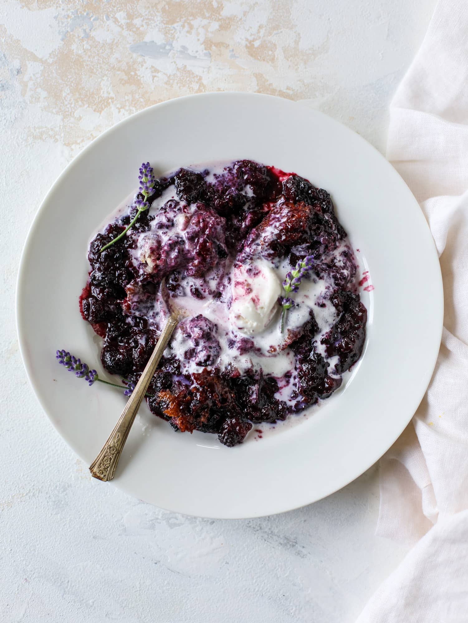 This black raspberry cobbler is a summer dream come true! The bursting black raspberries are rich and sweet, then add in a touch of lavender for incredible flavor and you're all set. The cobbler cake topping is perfect for vanilla ice cream. Win! I howsweeteats.com #black #raspberry #cobbler #lavender #summer #desserts #icecream