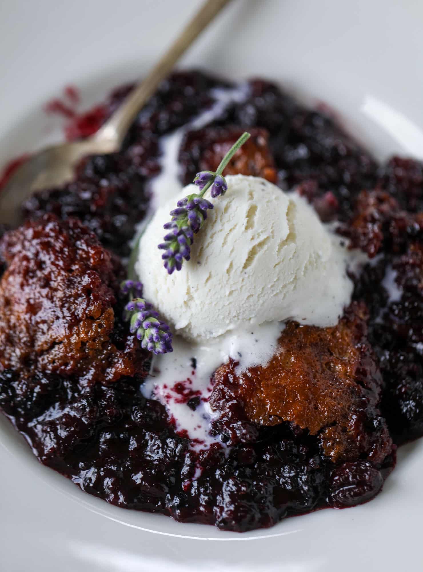 This black raspberry cobbler is a summer dream come true! The bursting black raspberries are rich and sweet, then add in a touch of lavender for incredible flavor and you're all set. The cobbler cake topping is perfect for vanilla ice cream. Win! I howsweeteats.com #black #raspberry #cobbler #lavender #summer #desserts #icecream