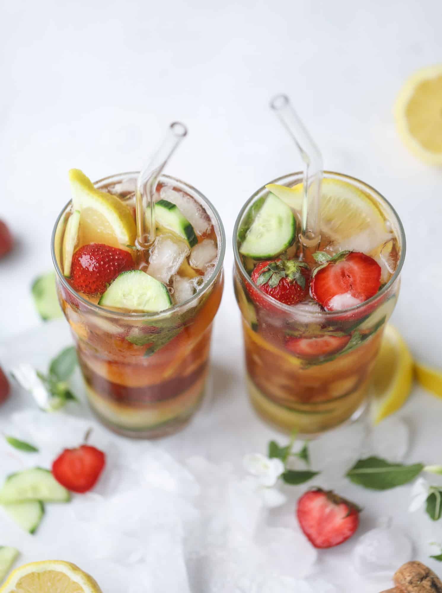 I love a delicious Pimm's Cup in the heart of summer! This was is topped with sparkling rosé wine and filled with strawberries, cucumbers and lemon wedges. It's super refreshing and perfect on hot hot days! I howsweeteats.com #pimms #cup #recipe #cocktails #rosé #sparkling #summer