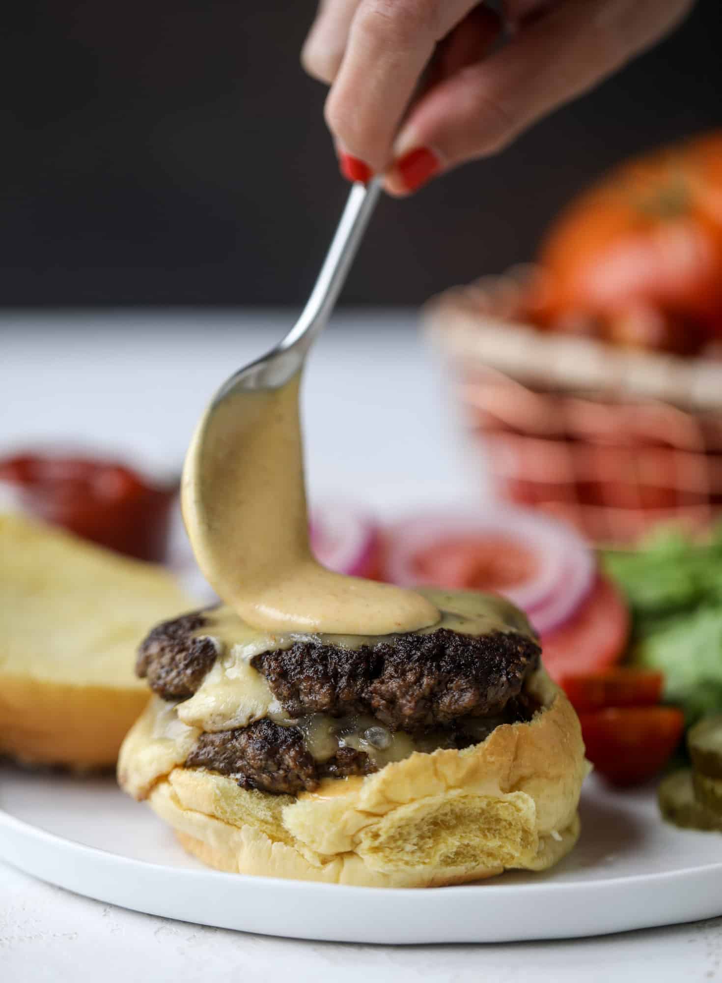 These smash burgers are to die for! All you need are a few ingredients and 30 minutes to make these smash burgers happen. Topped with melty smoked gouda and topped with a creamy, tangy house sauce, these are the best burgers ever! I howsweeteats.com #smash #burgers #smoked #gouda #special #sauce