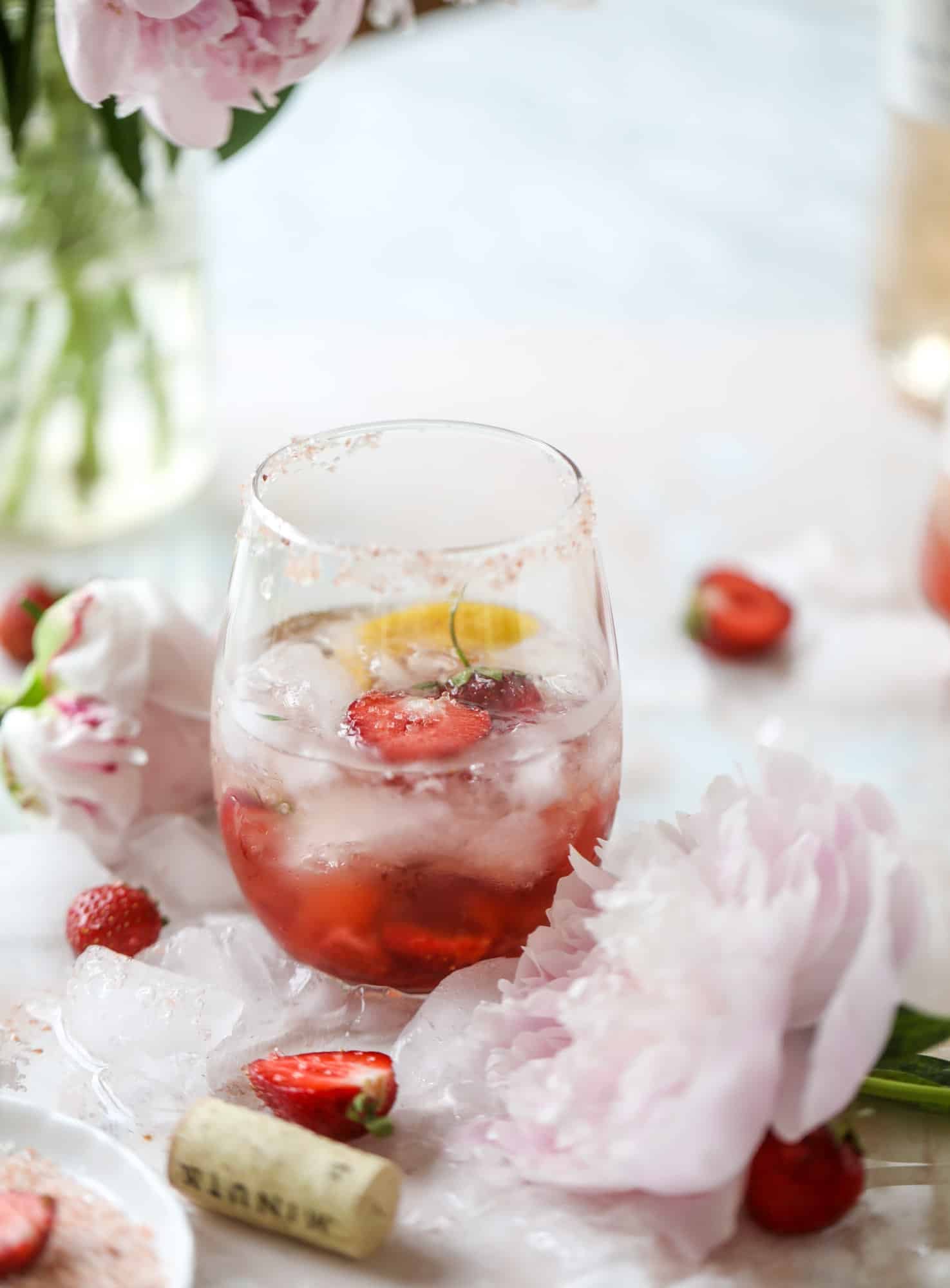 This tequila rosé spritz cocktail is perfectly refreshing for hot summer nights. A mix between a margarita and spritzer, this starts with muddled strawberries and honey, a shot of tequila and is topped off with your favorite rosé wine! I howsweeteats.com #tequila #rosé #wine #spritz #cocktail #strawberries