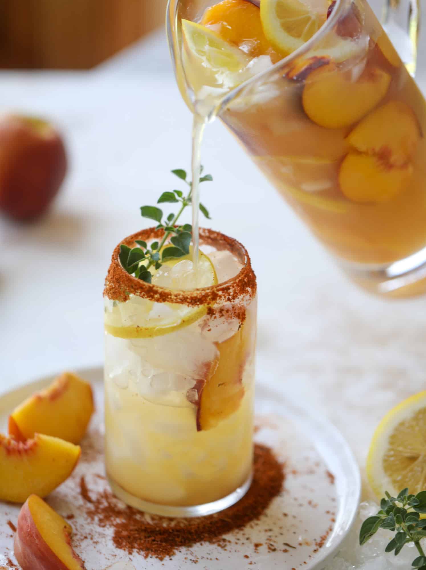 This peach lemonade is super refreshing and a bit spicy for a hot and sunny summer day. It's sweet and fresh and the rim is dipped in a cajun seasoning, bringing the best bite of heat to this perfect summer drink. So fresh! I howsweeteats.com #peach #lemonade #cajun #summer #mocktail #lemon #drink