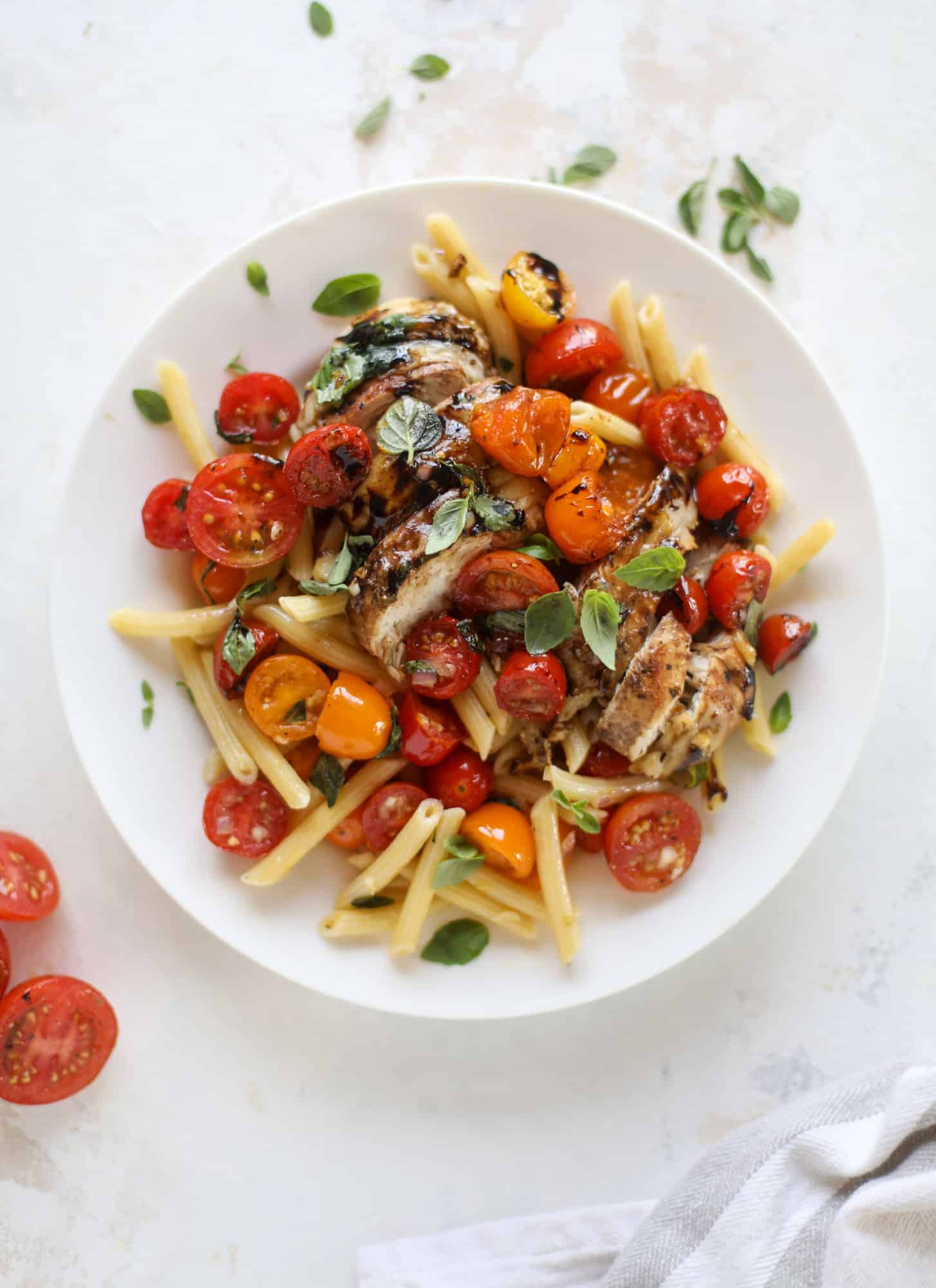 This bruschetta chicken is the perfect summer garden meal! Juicy, flavorful chicken topped with fresh tomatoes, garlic, basil and balsamic glaze, along with a touch of cheese. Served with pasta, it's an incredible meal. I howsweeteats.com #bruschetta #chicken #pasta #tomatoes #basil