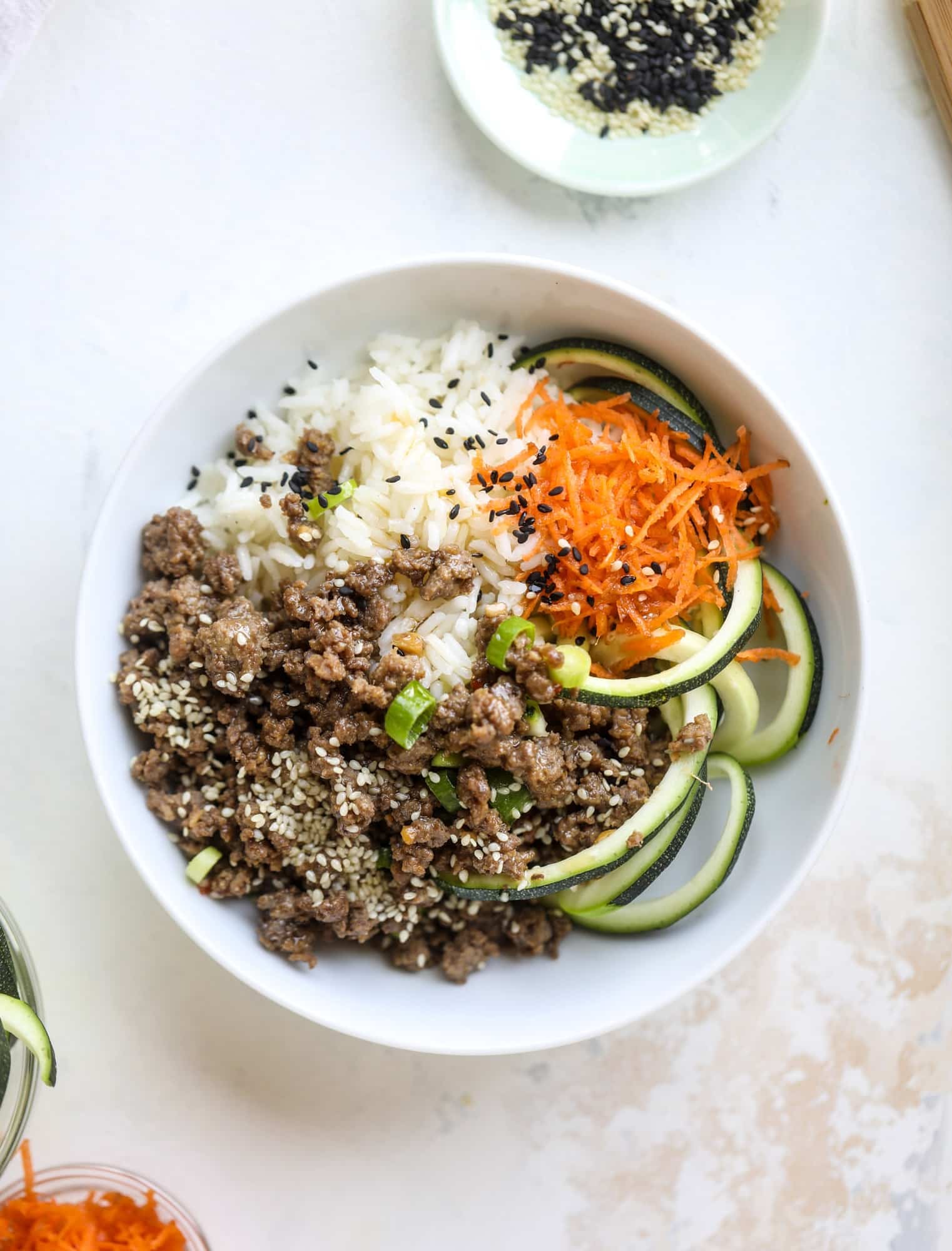 These korean beef bowls are so packed full of flavor that you won't want to eat anything else! Serve the beef with zucchini noodles, grated carrot and jasmine rice for a satisfying, flavor-packed bowl that comes together easily and quick! I howsweeteats.com #korean #beef