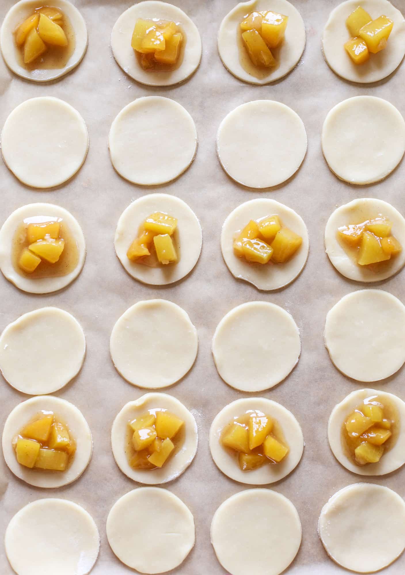 These little peach hand pies are super easy to make and oh-so delicious for summer! A warm and syrupy homemade peach filling made with brown sugar and bourbon, stuck inside a flakey all-butter crust and sprinkled with coarse sugar. SO GOOD. I howsweeteats.com #peach #hand #pies #mini #dessert #summer