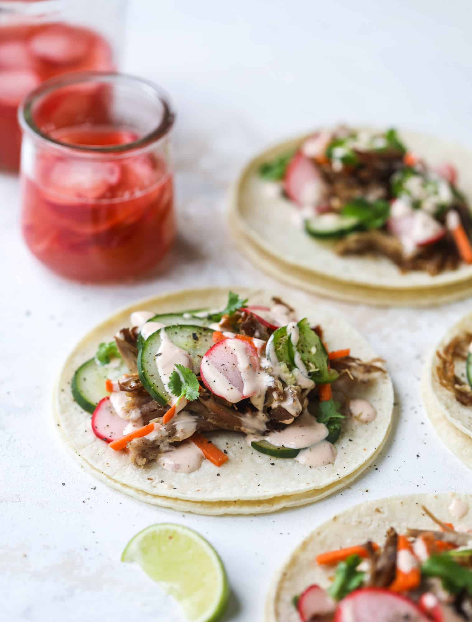 These bahn mi tacos are the perfect twist on the classic sandwich! Juicy pulled pork, pickled veggies, a tangy crema and loads of flavor. Bahn mi tacos are a delish weeknight meal or also work great if you have pork leftovers! I howsweeteats.com #bahn #mi #tacos #pork #dinner