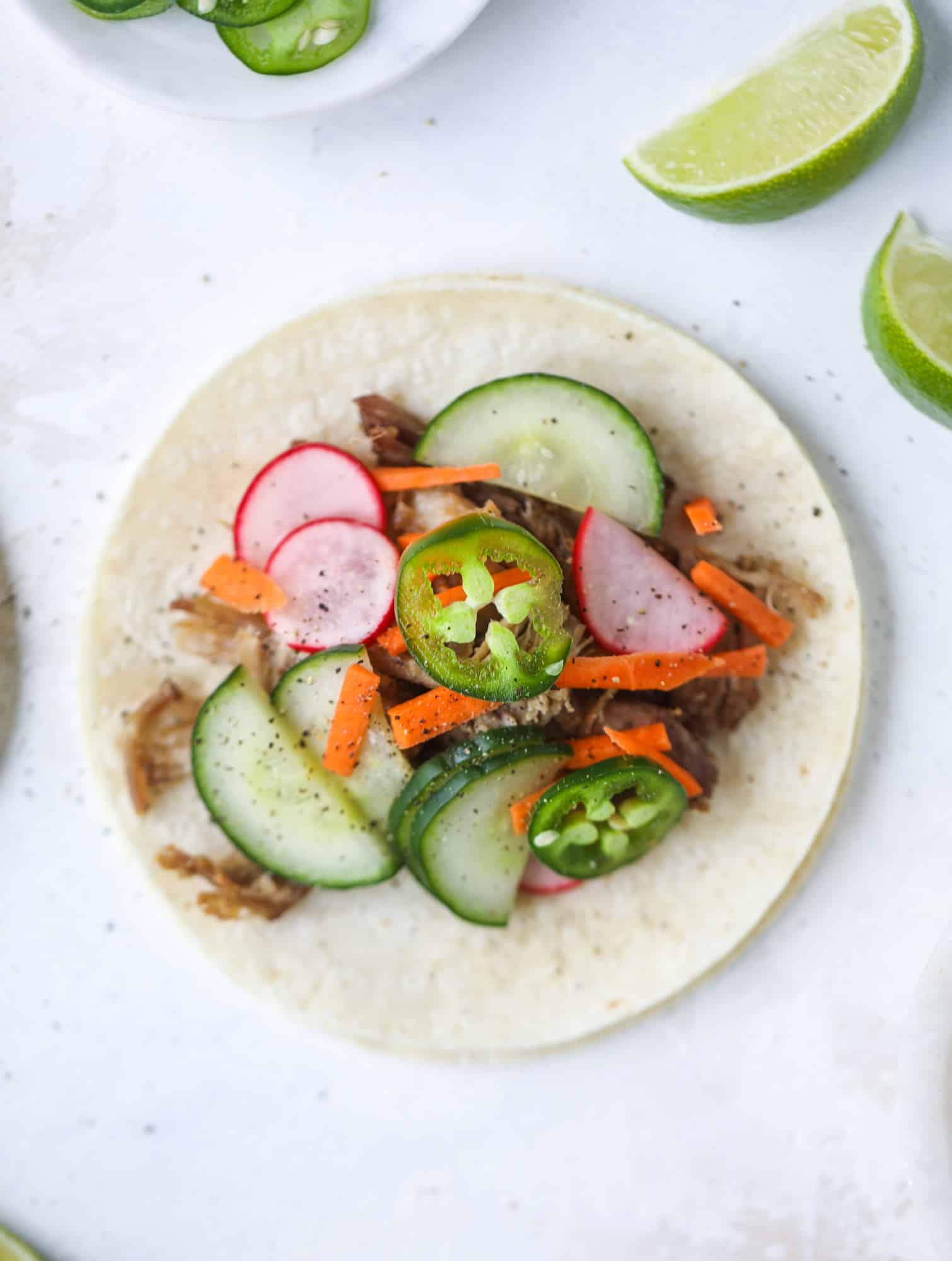 These bahn mi tacos are the perfect twist on the classic sandwich! Juicy pulled pork, pickled veggies, a tangy crema and loads of flavor. Bahn mi tacos are a delish weeknight meal or also work great if you have pork leftovers! I howsweeteats.com #bahn #mi #tacos #pork #dinner