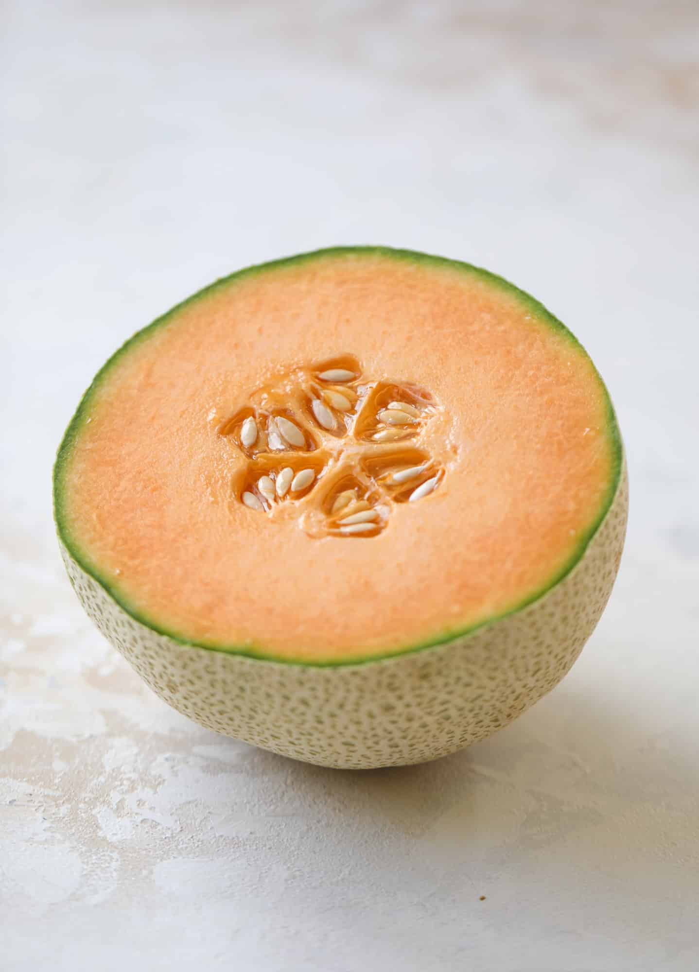 This cantaloupe daiquiri is the perfect way to celebrate summer! Freshly juiced melon, lime juice, rum and maraschino cherries - it's refreshing and cool and a fantastic cocktail to have during happy hour! Isn't the color amazing too?! I howsweeteats.com #cantaloupe #cocktail #daiquiri #lime #rum #summer