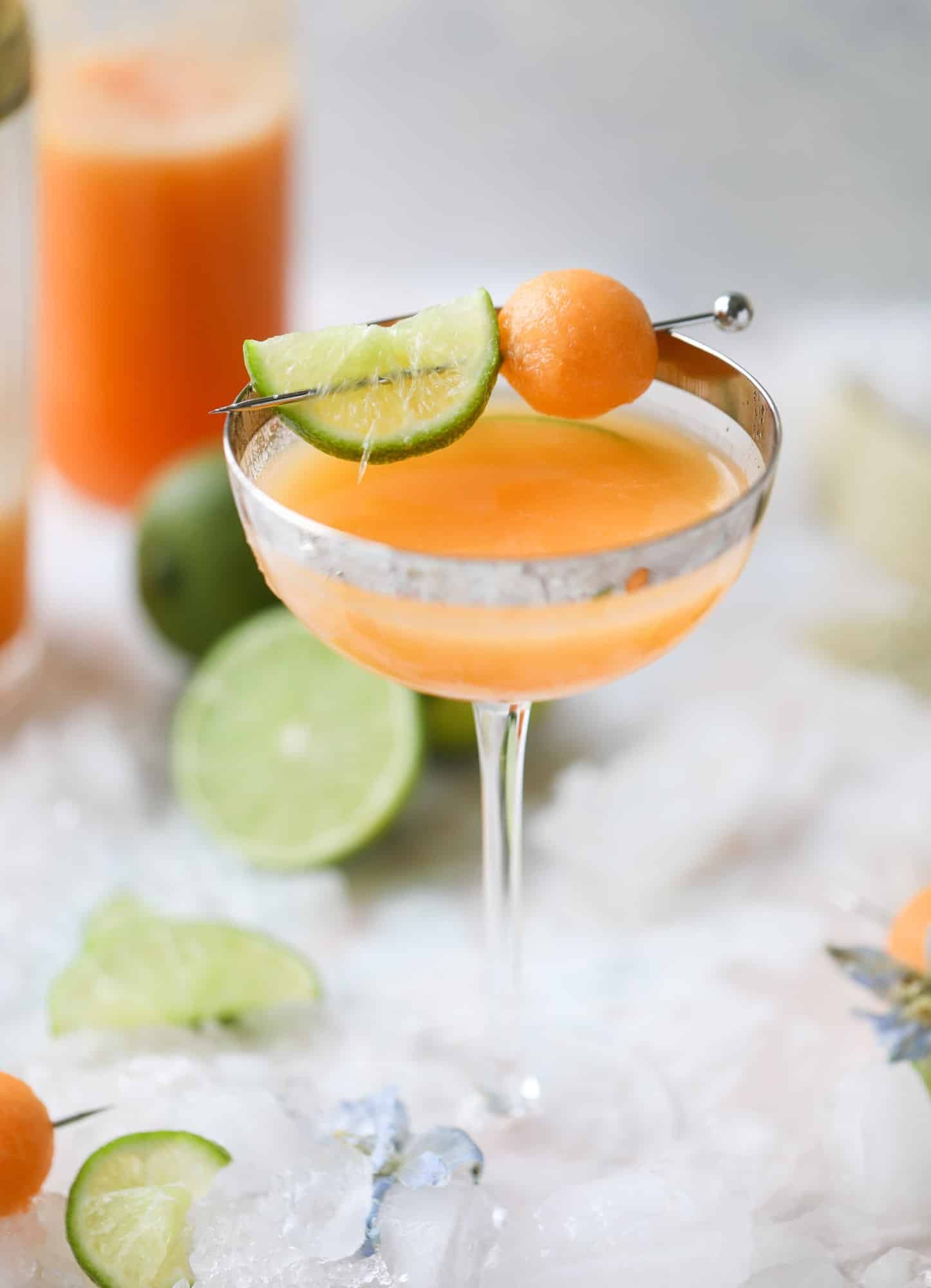 This cantaloupe daiquiri is the perfect way to celebrate summer! Freshly juiced melon, lime juice, rum and maraschino cherries - it's refreshing and cool and a fantastic cocktail to have during happy hour! Isn't the color amazing too?! I howsweeteats.com #cantaloupe #cocktail #daiquiri #lime #rum #summer