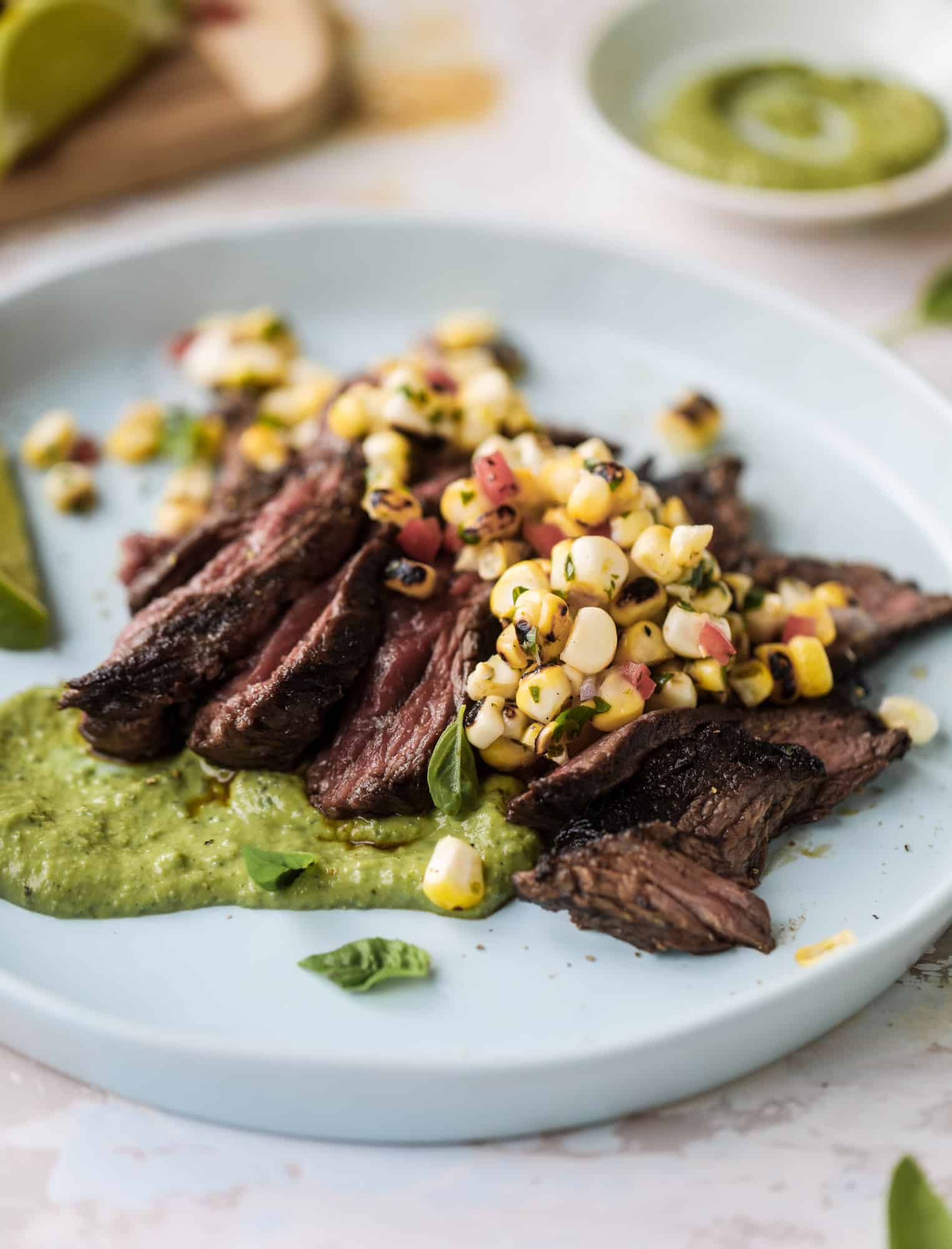 This skirt steak recipe is so super easy and delicious! Marinate it for a bit, prepare it to your liking then serve it with the most flavorful avocado pesto and grilled corn relish. Feels like a fancy restaurant meal and will make you love skirt steak forever! I howsweeteats.com #skirt #steak #avocado #pesto #corn #relish #recipes
