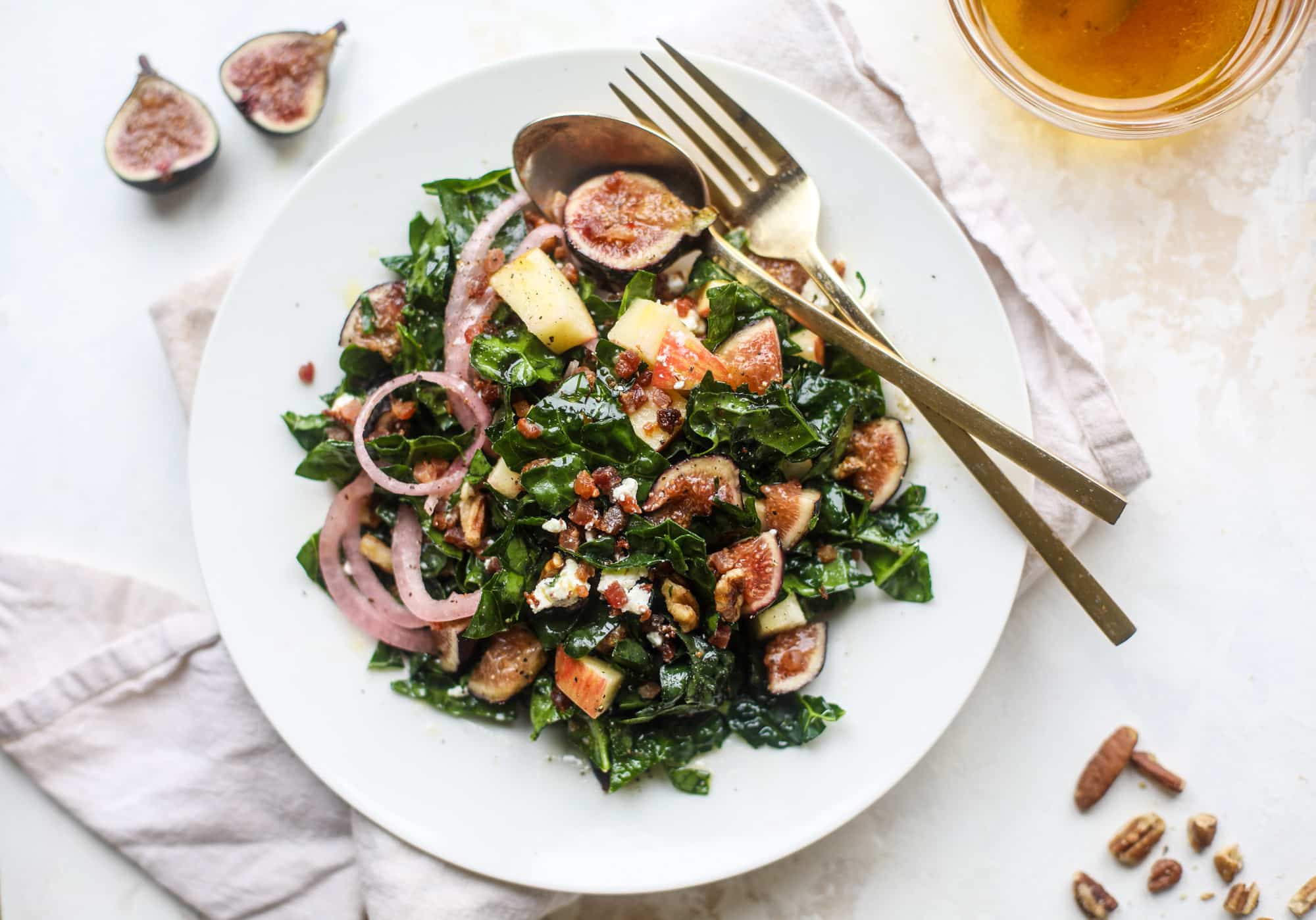 This fall kale salad is perfect for the season and full of so much delicious flavor! Shredded kale, honeycrisp apple, fresh figs, pancetta, pickled onions, pecans and goat cheese come together with a maple cider vinaigrette for salad heaven. I howsweeteats.com #fall #kale #salad #apples #figs #pecans