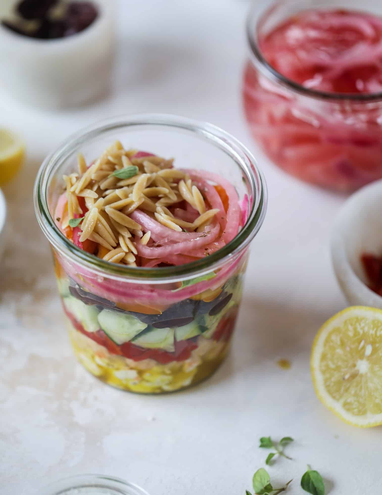 This incredible greek orzo salad in a jar is to die for! The recipe is so easy and flavorful, super satisfying and perfect for meal prep. This salad in a jar is a delicious lunch idea for the weekdays and keeps you feeling full and happy! I howsweeteats.com #salad #jar #greek #orzo #recipes #healthy #lunch #mealprep