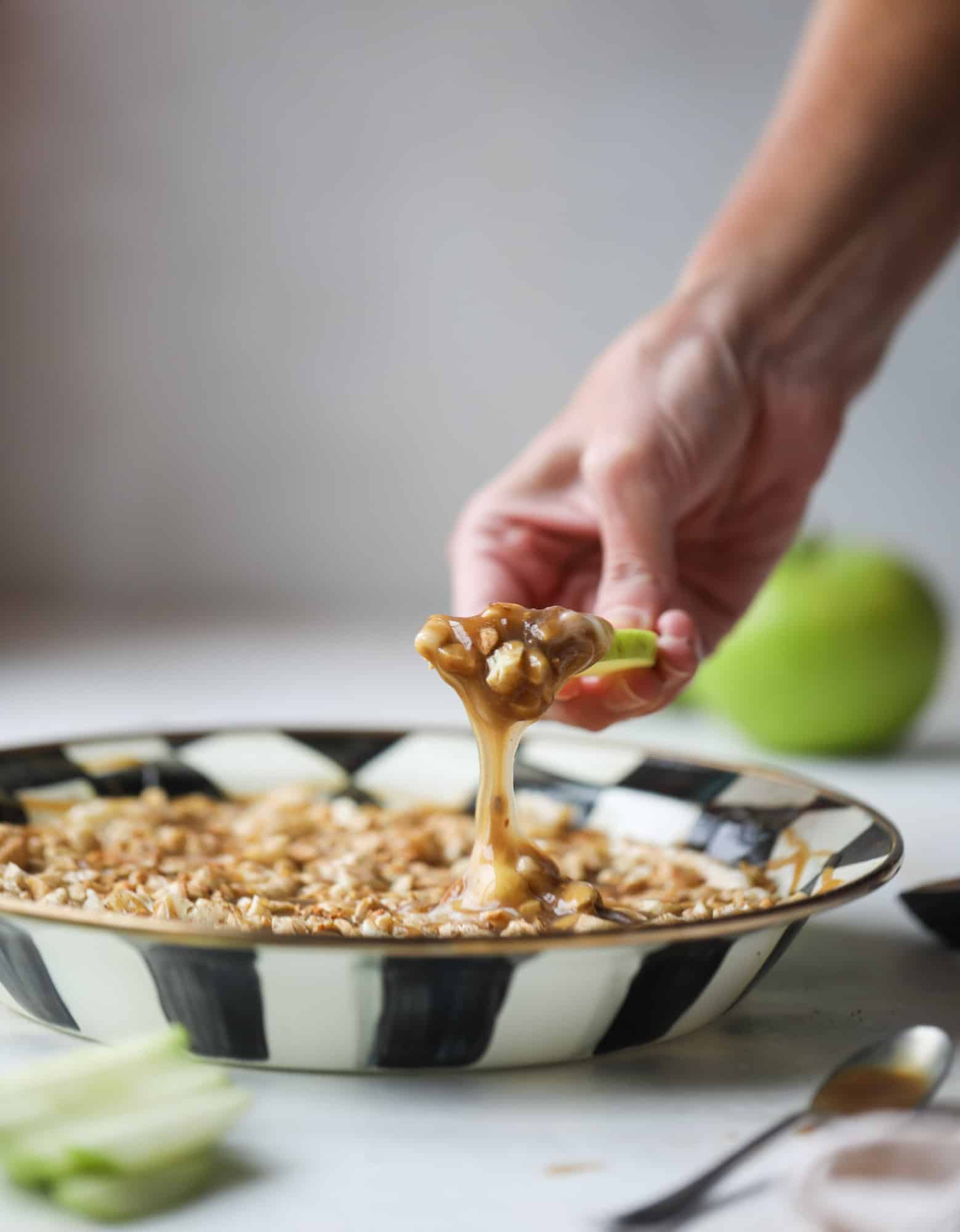 This caramel apple dip is my take on the old-school cream cheese based dip that is super delicious! Here, we have a mascarpone base with a bourbon caramel sauce, topped with roasted chopped cashews. Just add apples! I howsweeteats.com #caramel #apple #dip #appetizer #snack