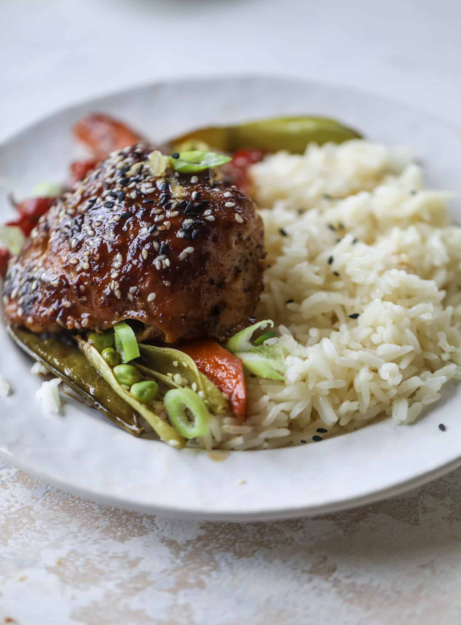 This one pan sesame chicken and veggies is so easy and delicious! It's the perfect weeknight meal that is packed with flavor. The chicken and veggies are great on their own but also wonderful when paired with brown rice or quinoa! I howsweeteats.com #one #pan #sesame #chicken #dinner #easy