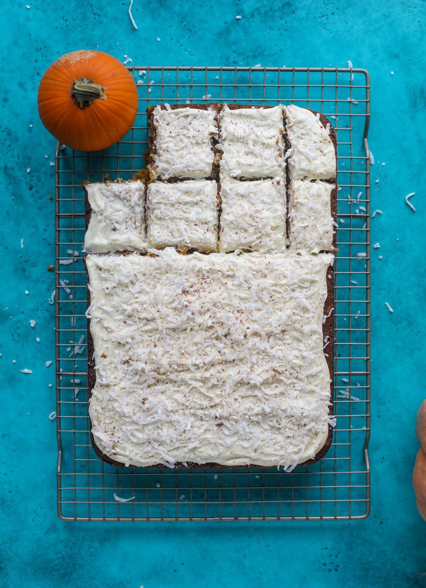 This pumpkin coconut cake is super tender and delicious and comes together quickly in a baking dish! It's spiced for the season and covered in a fluffy coconut cream cheese frosting. You can made it ahead of time for a crowd and it's a huge hit! I howsweeteats.com #pumpkin #cake