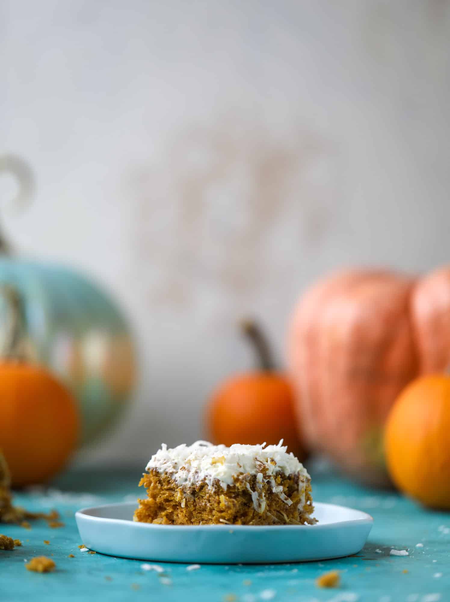 This pumpkin coconut cake is super tender and delicious and comes together quickly in a baking dish! It's spiced for the season and covered in a fluffy coconut cream cheese frosting. You can made it ahead of time for a crowd and it's a huge hit! I howsweeteats.com #pumpkin #cake