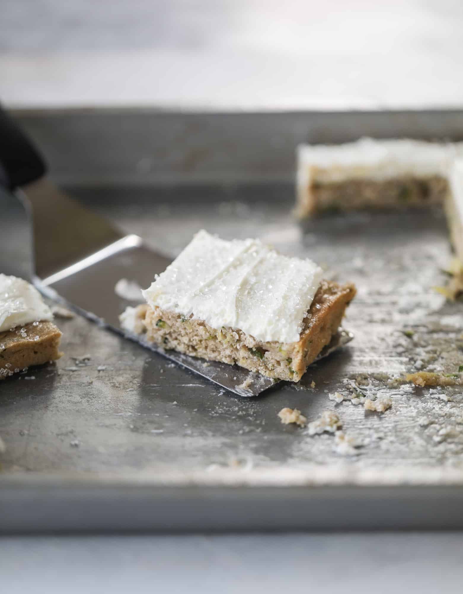 These zucchini bars with cream cheese icing are a fun twist on zucchini bread! Zucchini bars are super easy to make, have a little spice and a lot of flavor, topped with the creamiest cream cheese frosting. Delicious and simple! I howsweeteats.com #zucchini #bars #cream #cheese #icing #dessert