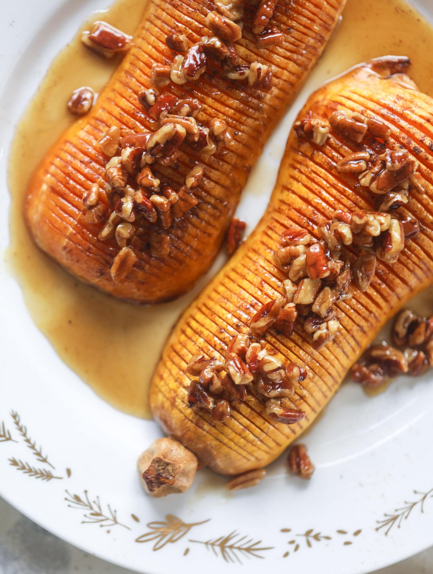 This hasselback butternut squash is perfect for Thanksgiving - and you can easily make it two ways! We have a maple pecan hassleback butternut squash and a brown butter sage hasselback butternut squash. Delicious! I howsweeteats.com #hasselback #butternutsquash