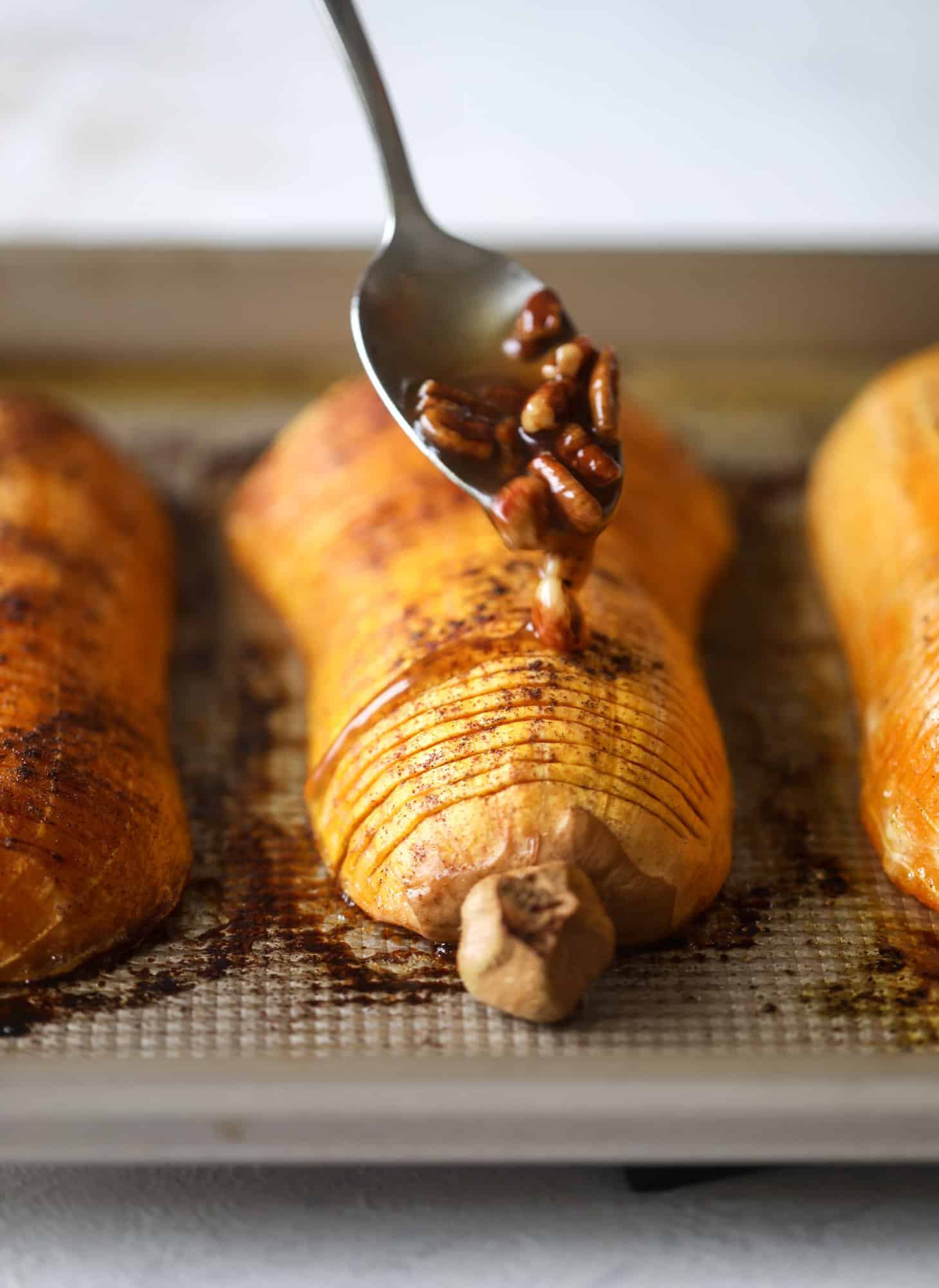 This hasselback butternut squash is perfect for Thanksgiving - and you can easily make it two ways! We have a maple pecan hassleback butternut squash and a brown butter sage hasselback butternut squash. Delicious! I howsweeteats.com #hasselback #butternutsquash