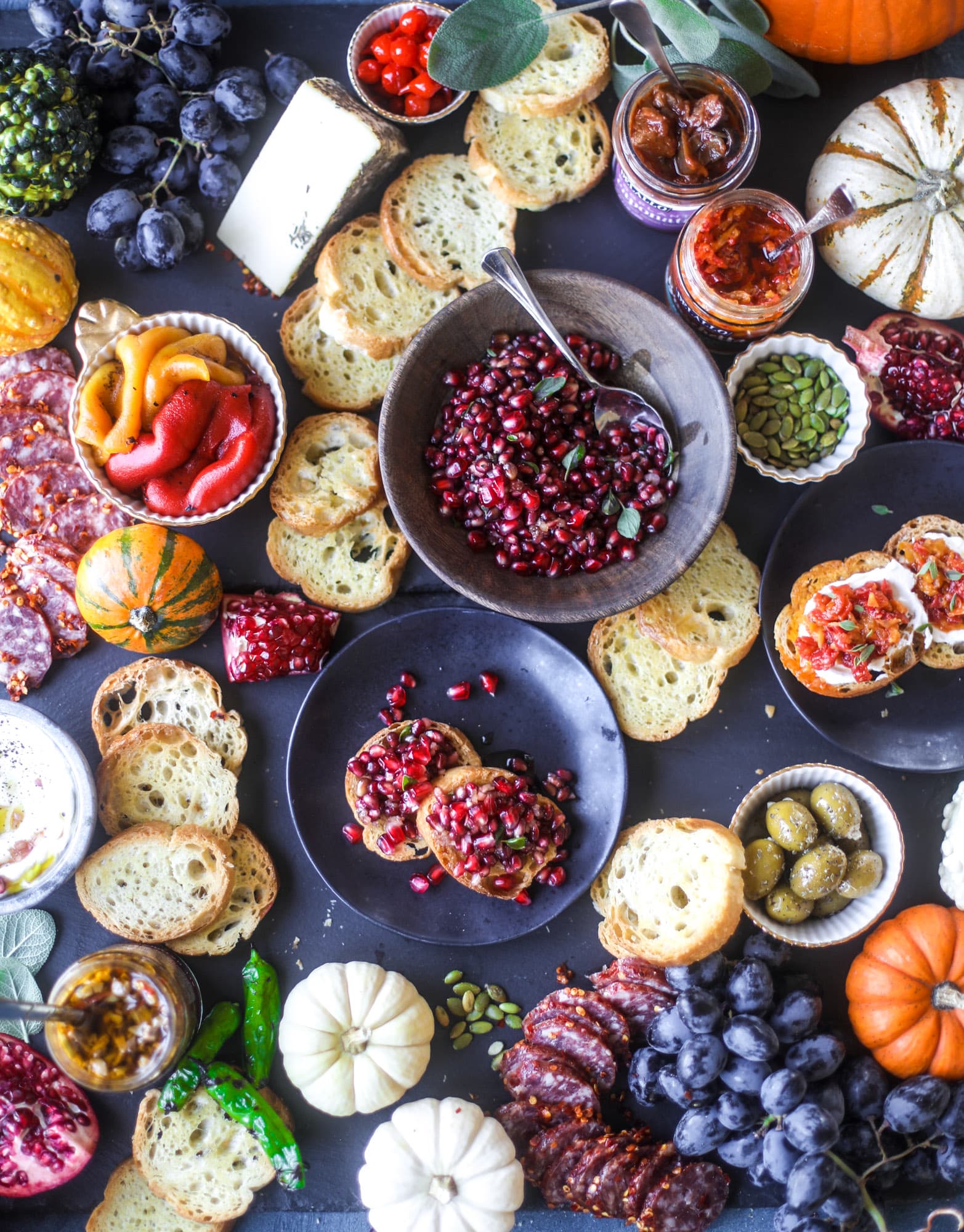 This is the perfect autumn harvest bruschetta board to feed a crowd or serve at a party! The standout is pomegranate relish with a cinnamon shallot vinaigrette, lots of toasty bread, bruschettas, cheese and olives. Everything that's delish! I howsweeteats.com #bruschetta #board