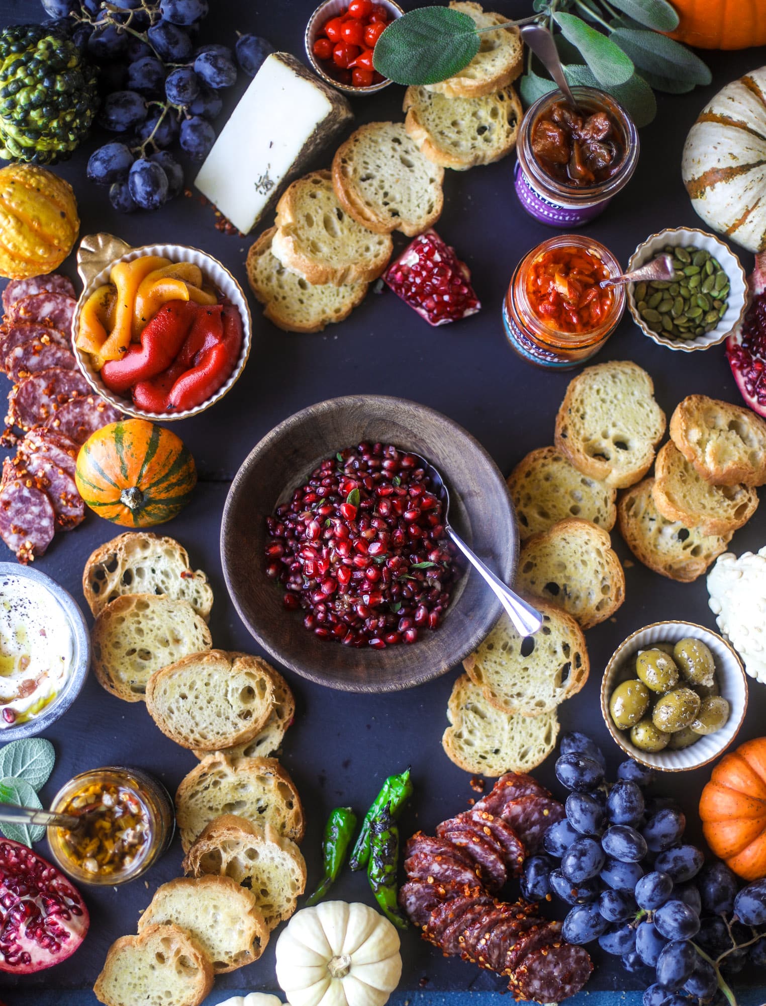 This is the perfect autumn harvest bruschetta board to feed a crowd or serve at a party! The standout is pomegranate relish with a cinnamon shallot vinaigrette, lots of toasty bread, bruschettas, cheese and olives. Everything that's delish! I howsweeteats.com #bruschetta #board