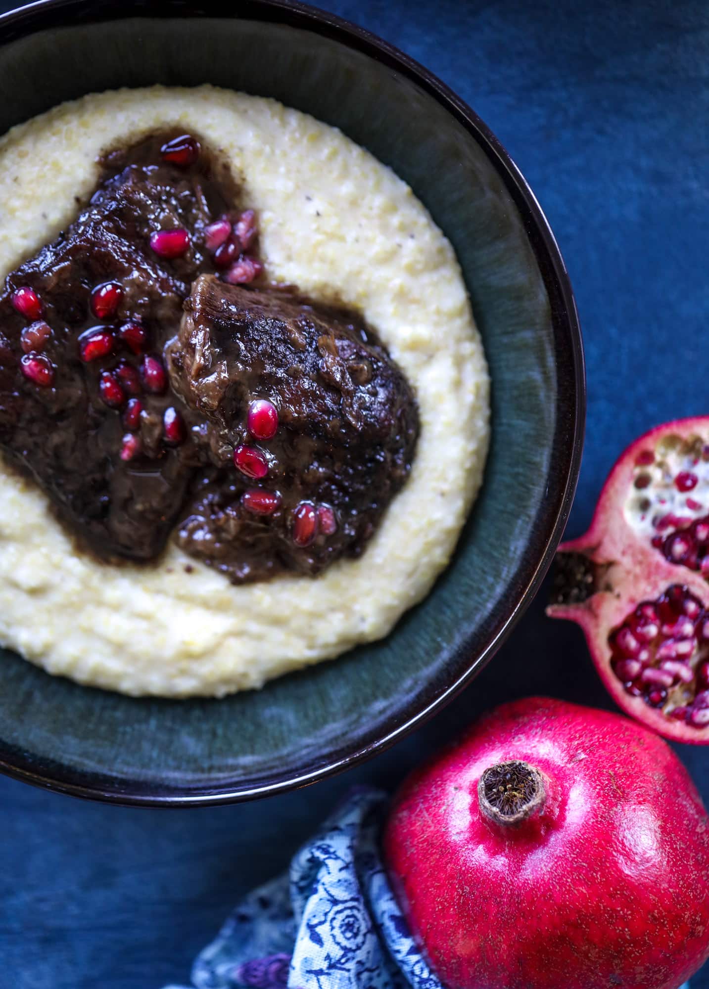 These pomegranate braised short ribs are an incredible take on comfort food! Pomegranate juice and molasses are the base of the recipe and after braising, you're left with tender, juicy and flavorful beef that is amazing served with polenta, potatoes or even in tacos. I howsweeteats.com #braised #shortribs