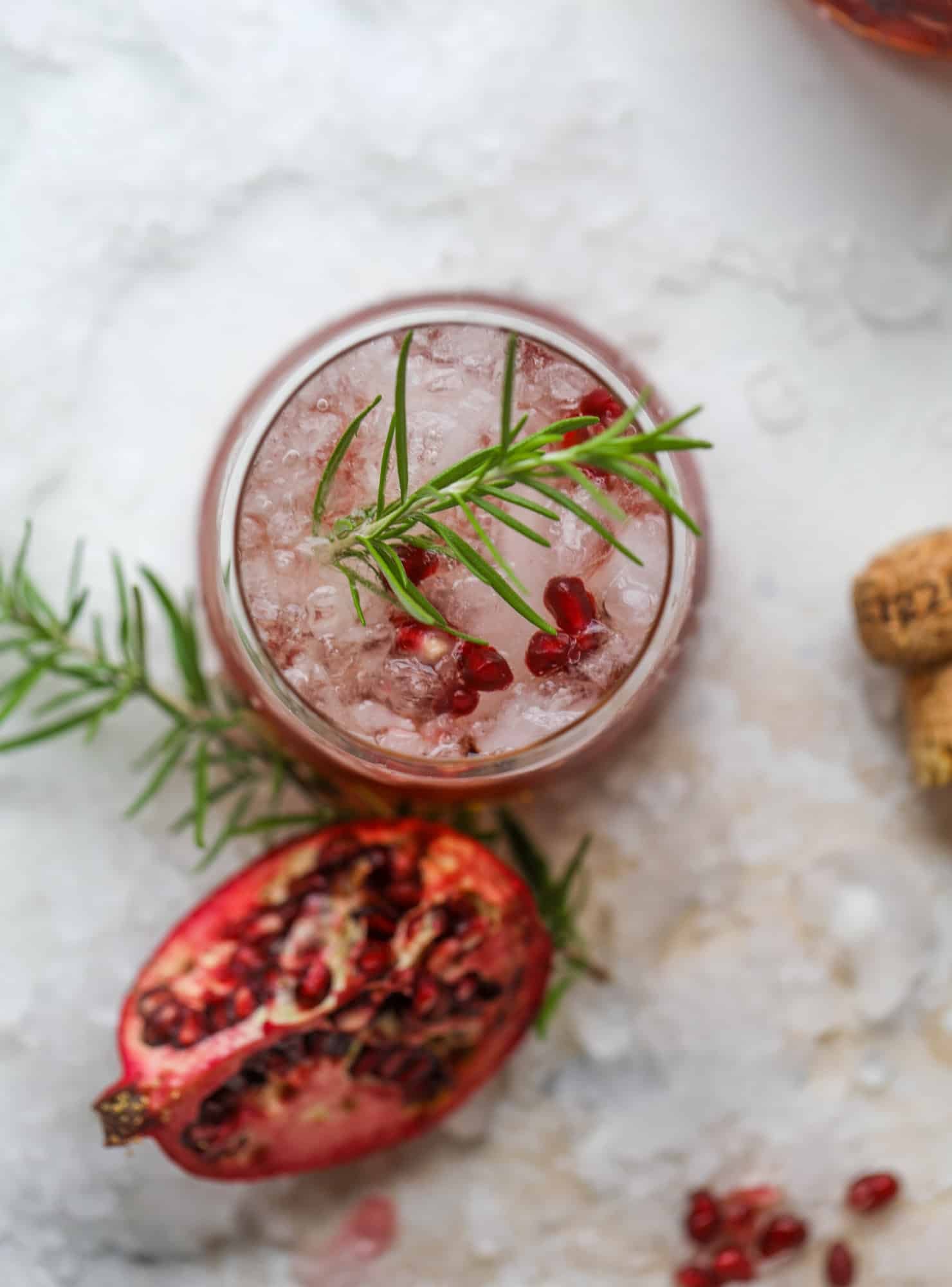 The pomegranate smash cocktail is a great drink for fall, Thanksgiving and the holiday season. Pomegranate juice, vodka and prosecco create a bubbly delicious drink that is garnished with pomegranate arils and rosemary. So festive! I howsweeteats.com #pomegranate #smash