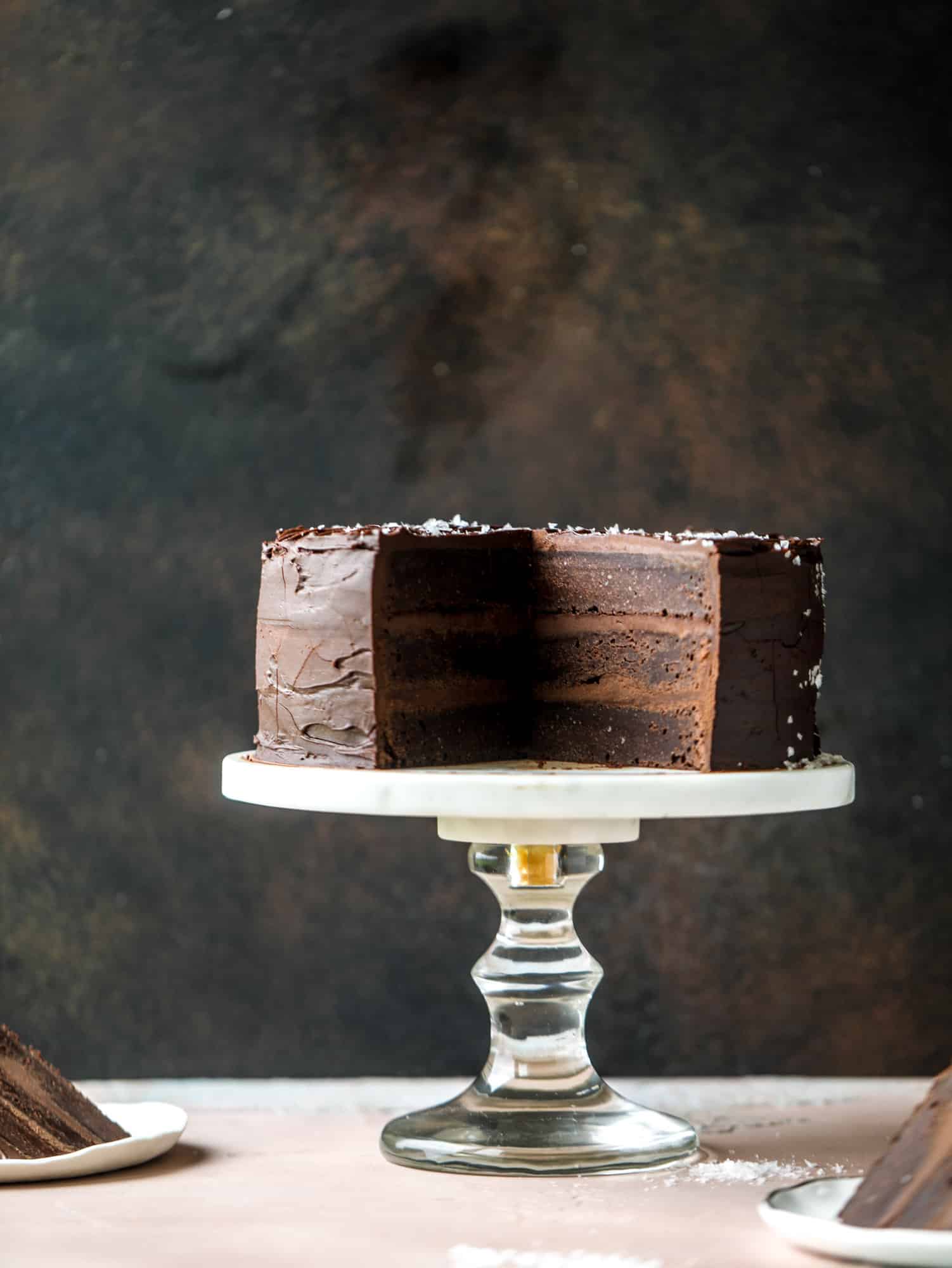 This salted dark chocolate stout cake is absolutely divine! It's ridiculously rich and perfect for a crowd or a party. Pumpkin stout batter is baked into fluffy laters and covered in a super fudgy chocolate ganache. Perfect for chocolate lovers! I howsweeteats.com #dark #chocolate #stout #cake #salted