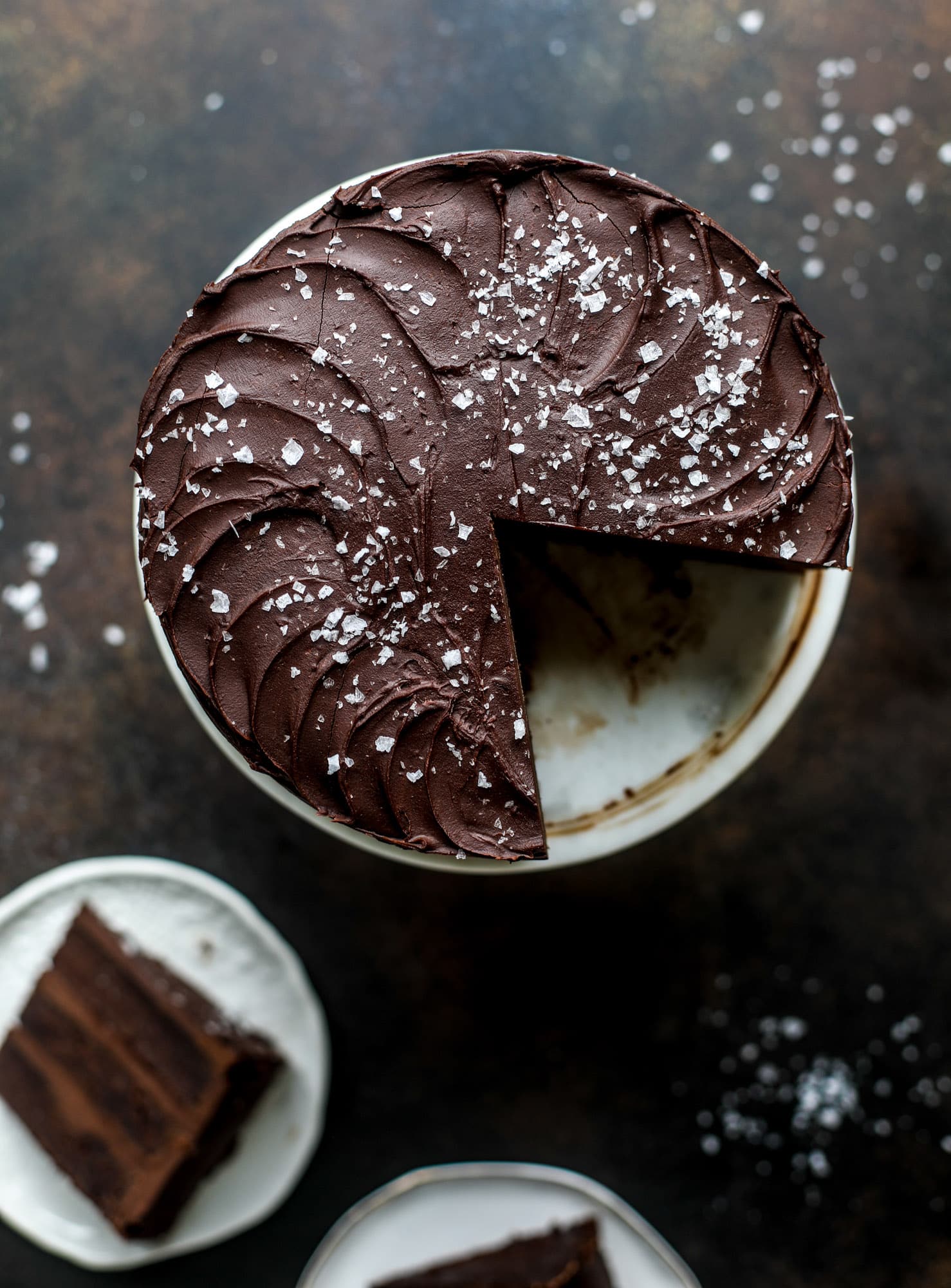 This salted dark chocolate stout cake is absolutely divine! It's ridiculously rich and perfect for a crowd or a party. Pumpkin stout batter is baked into fluffy laters and covered in a super fudgy chocolate ganache. Perfect for chocolate lovers! I howsweeteats.com #dark #chocolate #stout #cake #salted