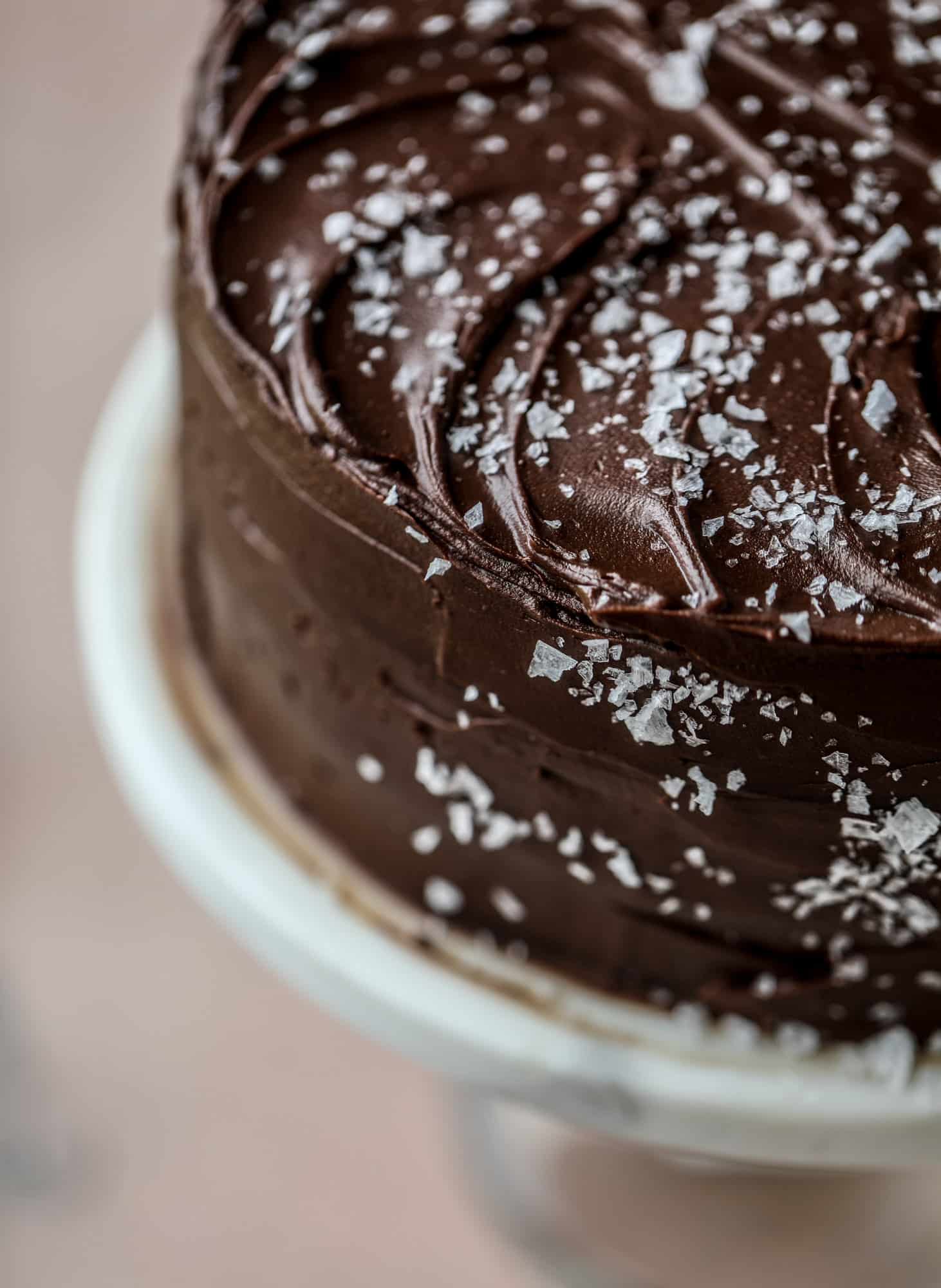This salted dark chocolate stout cake is absolutely divine! It's ridiculously rich and perfect for a crowd or a party. Pumpkin stout batter is baked into fluffy laters and covered in a super fudgy chocolate ganache. Perfect for chocolate lovers! I howsweeteats.com #dark #chocolate #stout #cake #salted
