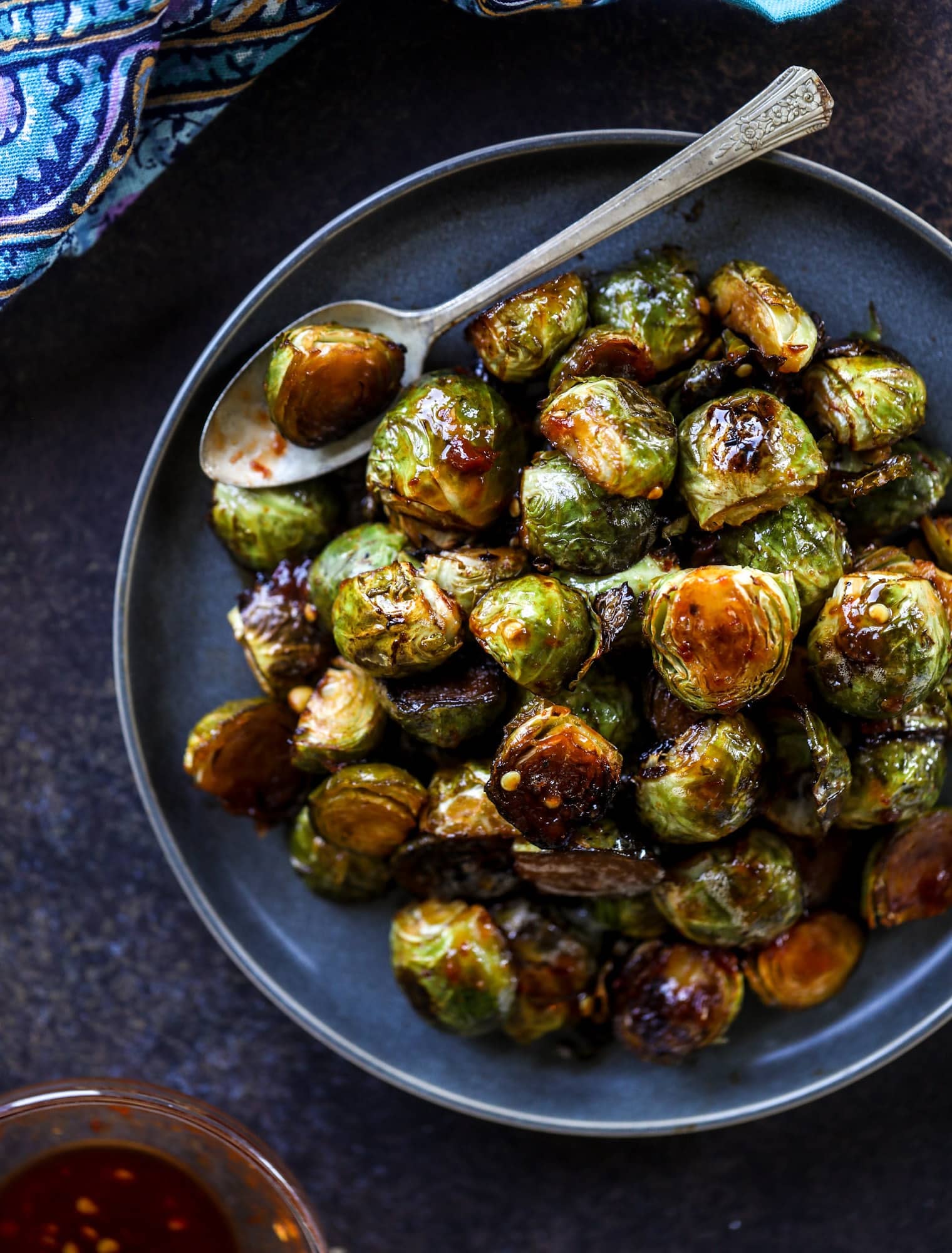 These sweet and spicy brussels sprouts are roasted to perfect and the most delicious side dish! It's a great way to elevate regular old brussels sprouts and make a fantastic side to to serve on a weeknight! I howsweeteats.com #spicy #brusselssprouts