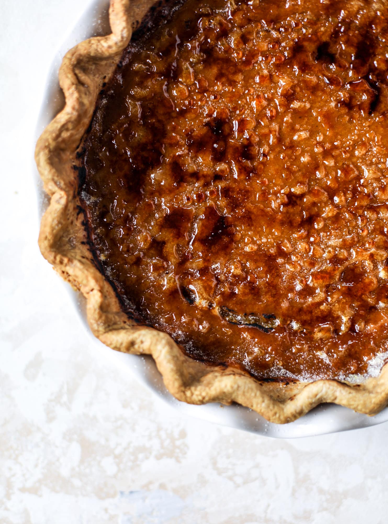 This brûlée pumpkin pie is the best of both worlds in pumpkin desserts! A delicious flaky crust, a creamy pumpkin filling and a crunchy, crispy topping - brûléed sugar right before serving. It's a whole new way to serve pumpkin pie! I howsweeteats.com #pumpkinpie #brulee