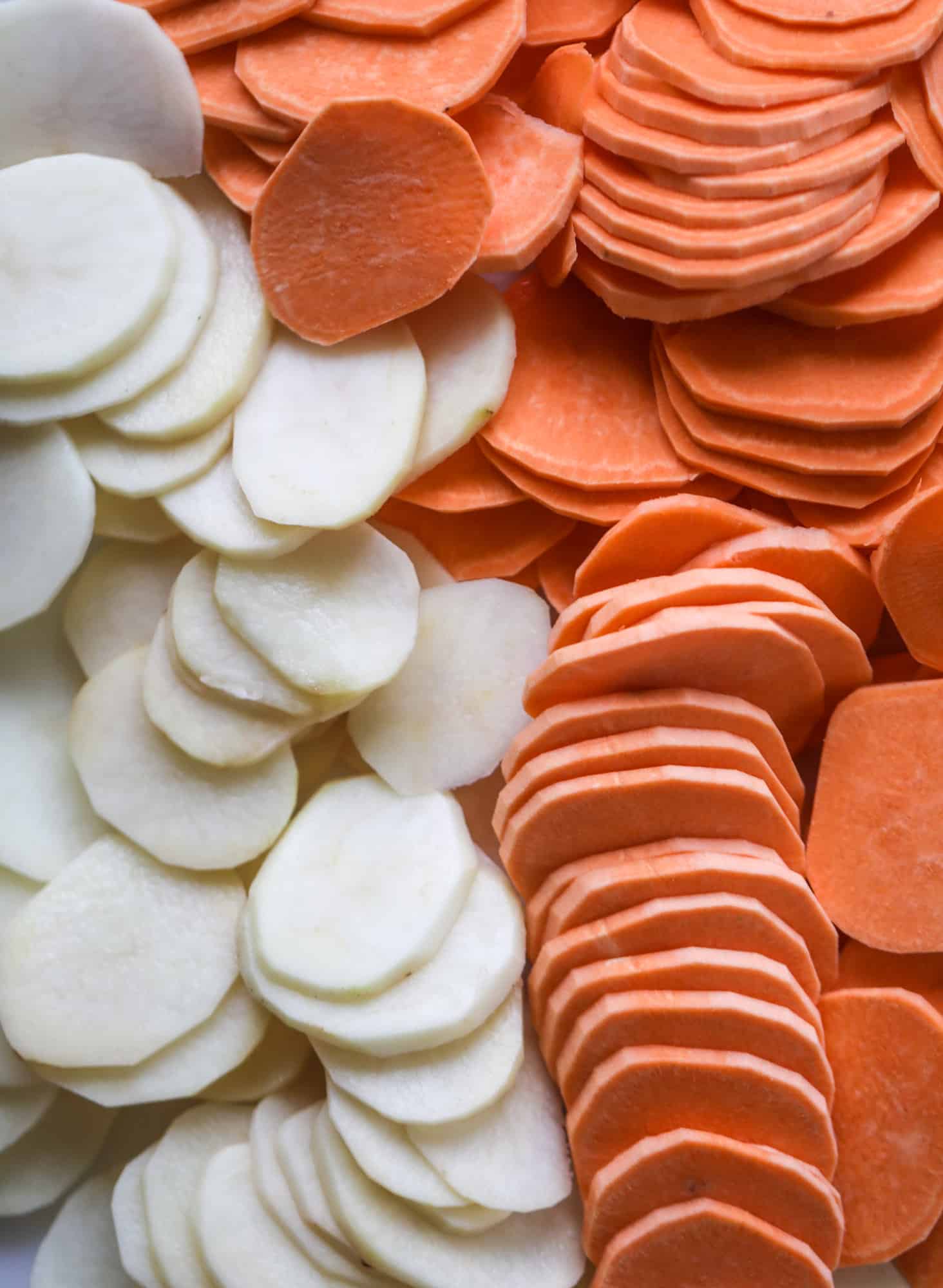 These scalloped potatoes are a cheese lover's dream. Sharp asiago and cream envelops idaho and sweet potatoes in these scalloped potatoes to please everyone! The crunchy asiago topping is irresistible. I howsweeteats.com #scalloped #potatoes