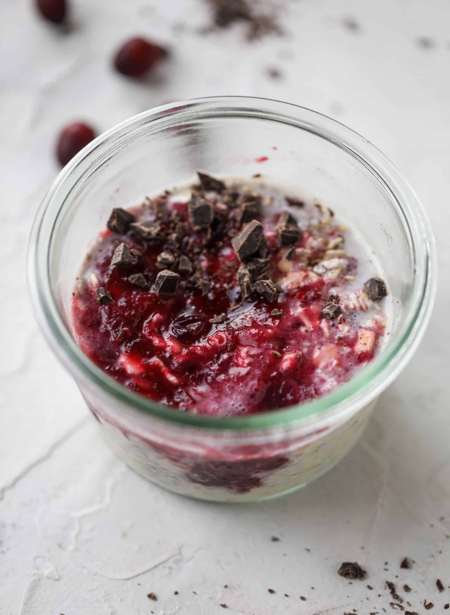 These leftover cranberry overnight oats are the perfect post-Thanksgiving breakfast! Leftover cranberry sauce and dark chocolate come together to flavor chewy, chilled overnight oats. Add on sliced almonds, chia seeds and hemp hearts for more deliciousness! I howsweeteats.com #overnight #oats