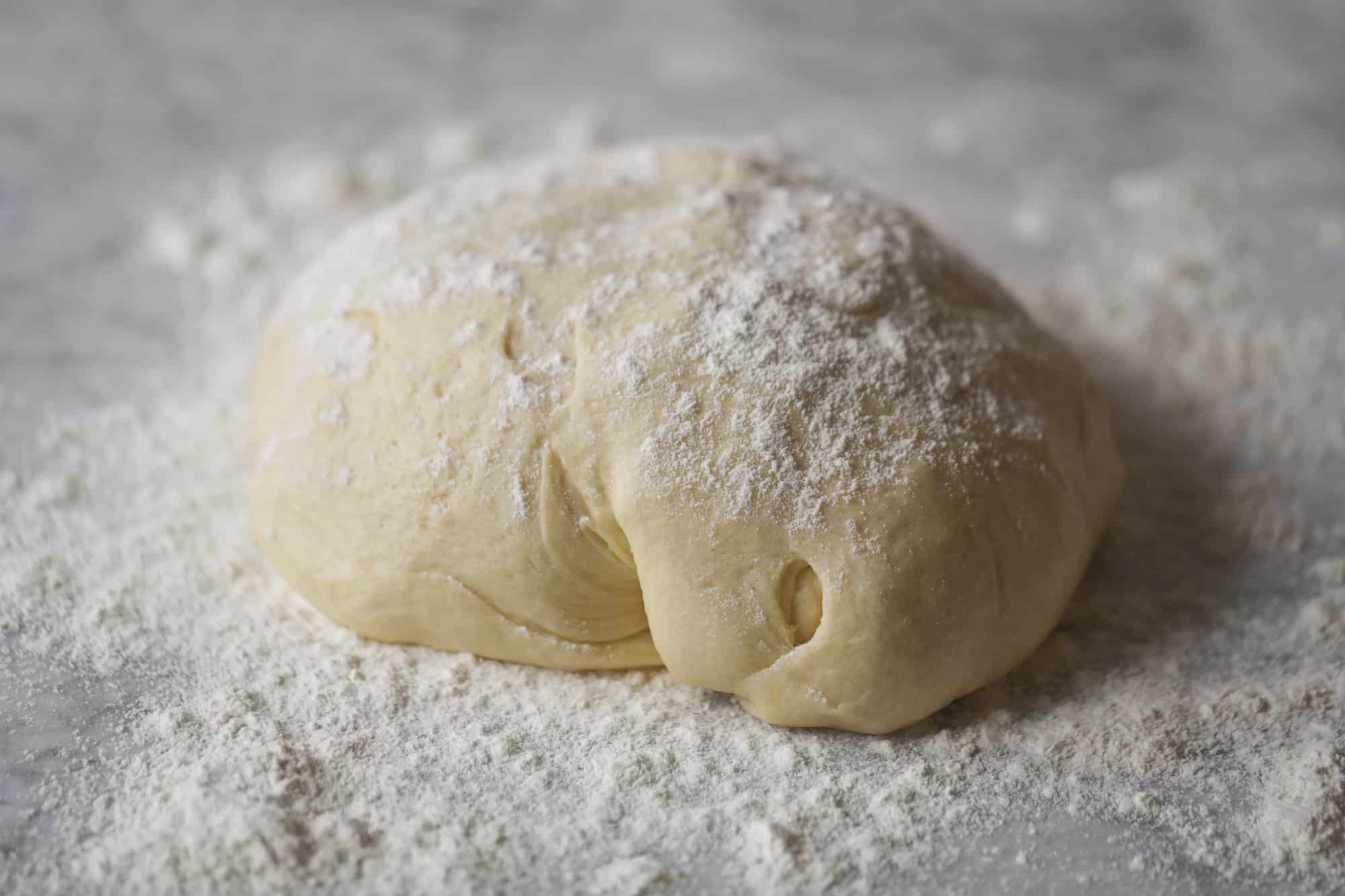 Garlic herb parker house rolls are full of incredibly buttery flavor! They are brushed with a garlic herb butter and are super fluffy, soft and tender. Perfect for Thanksgiving or the holidays and you can make the dough a bit ahead of time! I howsweeteats.com #parkerhouse #rolls