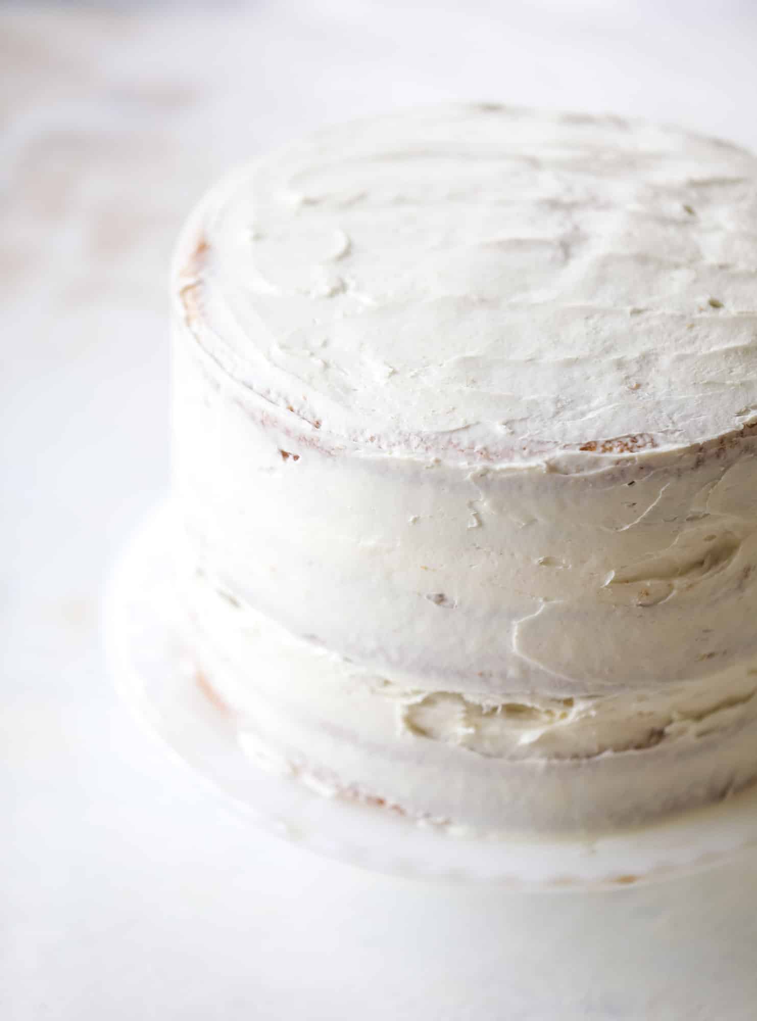 This pink peppermint cake is festive and delicious for the holidays! Layers of vanilla cake frosting with peppermint cream cheese frosting, covered in sparkly sugar and peppermint meringues. Couldn't be cuter! I #pinkpeppermint #cake