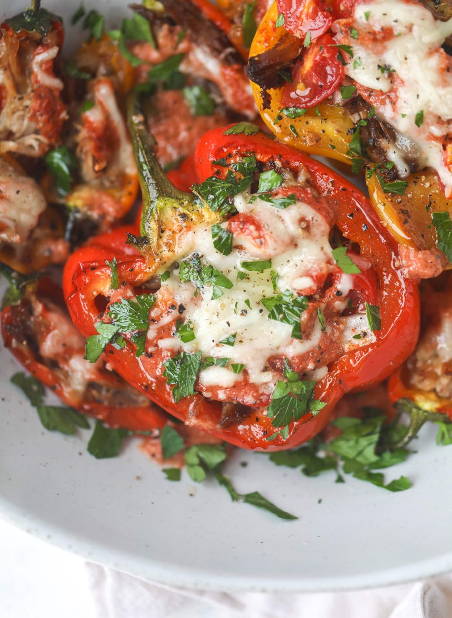 These pulled pork stuffed peppers are a delicious dinner idea for any weeknight! They work great with leftover pulled pork and the filling is totally customizable. They are flavorful, come together quickly and always a crowd pleaser! I howsweeteats.com #pulledpork #stuffedpeppers