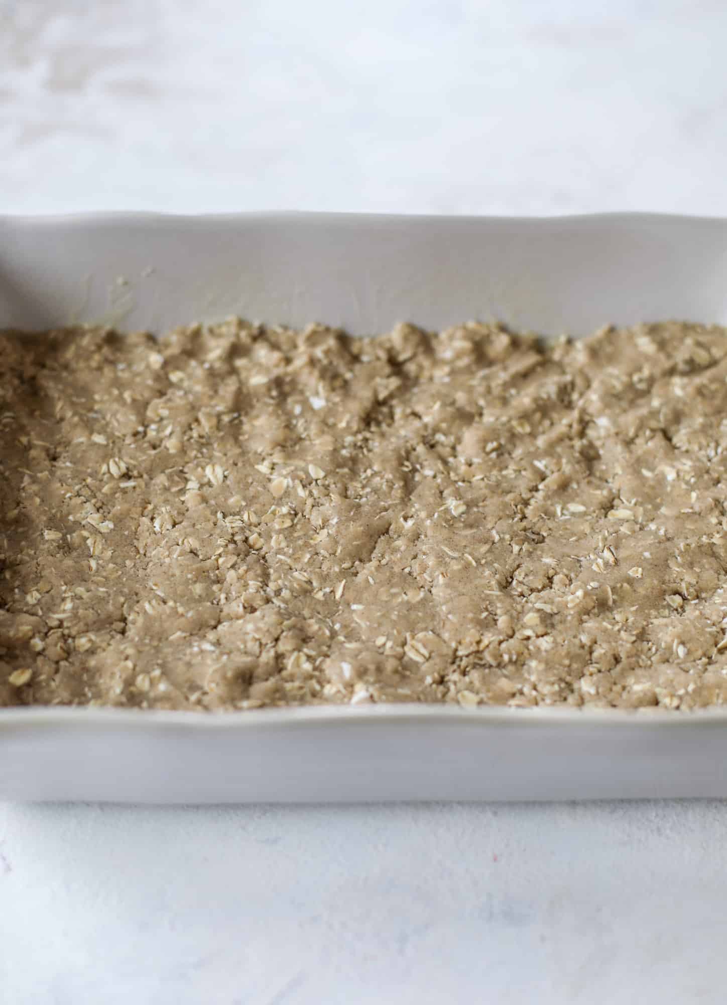 These snickerdoodle caramelitas have a layer of chewy, cinnamon sugared oatmeal bar topped with cream white chocolate and more crumbly, chewy oatmeal bites. They are super delicious and festive! I howsweeteats.com #snickerdoodle #caramelitas