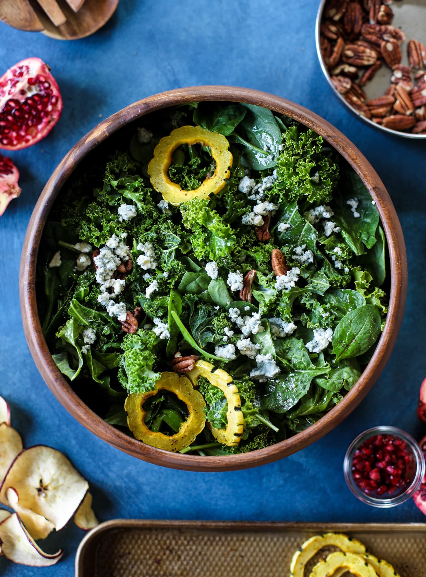 This thanksgiving salad is full of so much autumn flavor. It has toasted pomegranate, delicata squash, toasted pecans, creamy blue cheese and crunchy apple chips. It's light enough to serve before the big meal! I howsweeteats.com #thanksgiving #salad