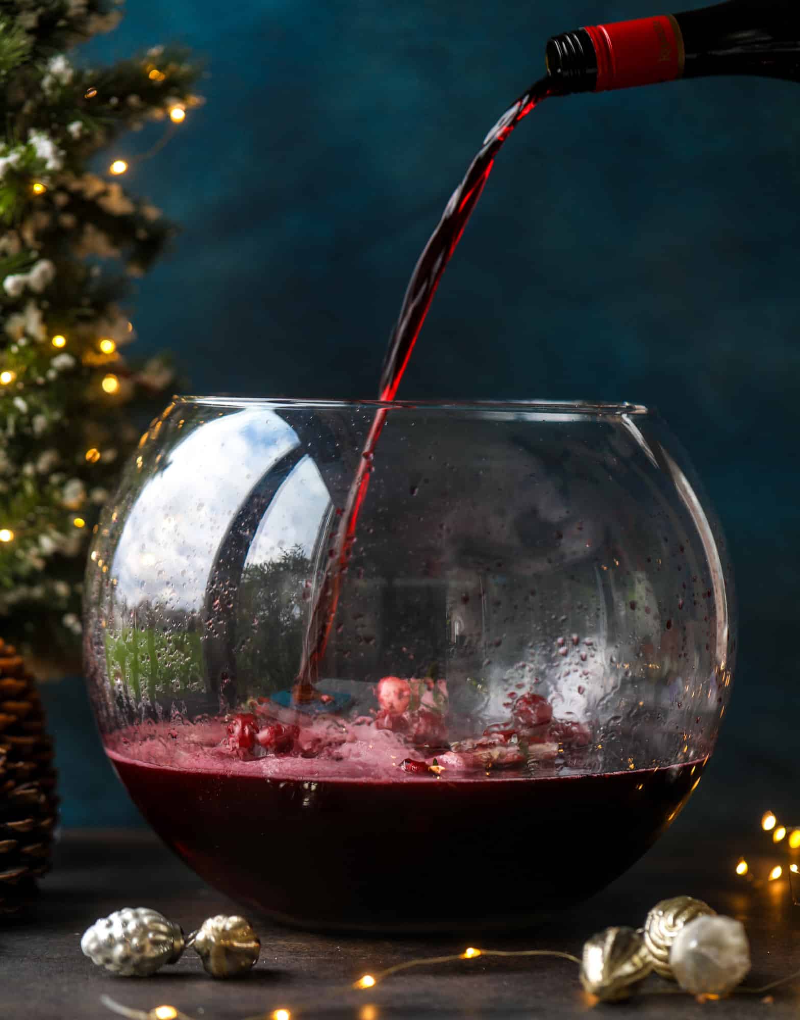 This tree trimming punch is the most perfect christmas punch to drink while decorating the tree! Rich red wine is the base and there's a bit of orange, some spice, cinnamon and a gorgeous jeweled holiday ice cubes! I howsweeteats.com #christmas #punch