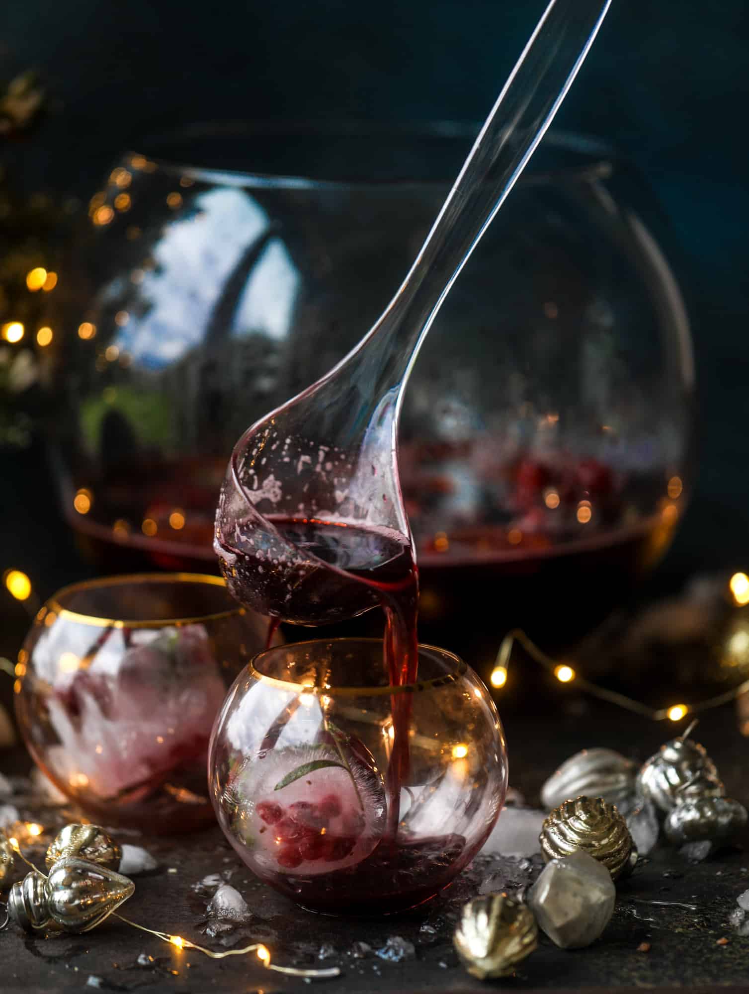 This tree trimming punch is the most perfect christmas punch to drink while decorating the tree! Rich red wine is the base and there's a bit of orange, some spice, cinnamon and a gorgeous jeweled holiday ice cubes! I howsweeteats.com #christmas #punch
