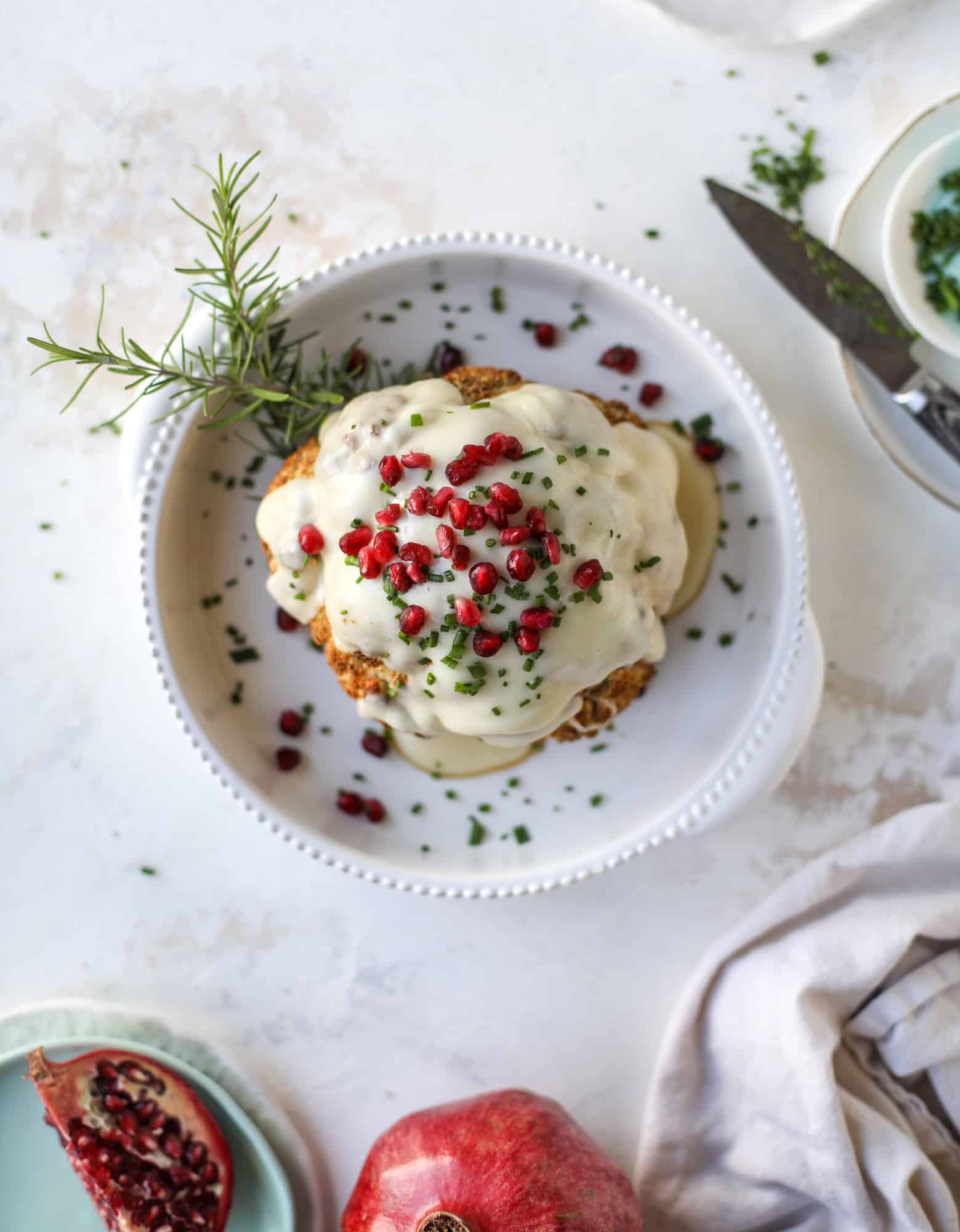 This whole roasted cauliflower fondue is roasted to toasty perfection and then covered in a fondue cheese sauce! Sprinkled with a festive garnish, it's the perfect appetizer or side dish for your dinner party, weeknight meal or movie night! I howsweeteats.com #wholeroasted #cauliflower