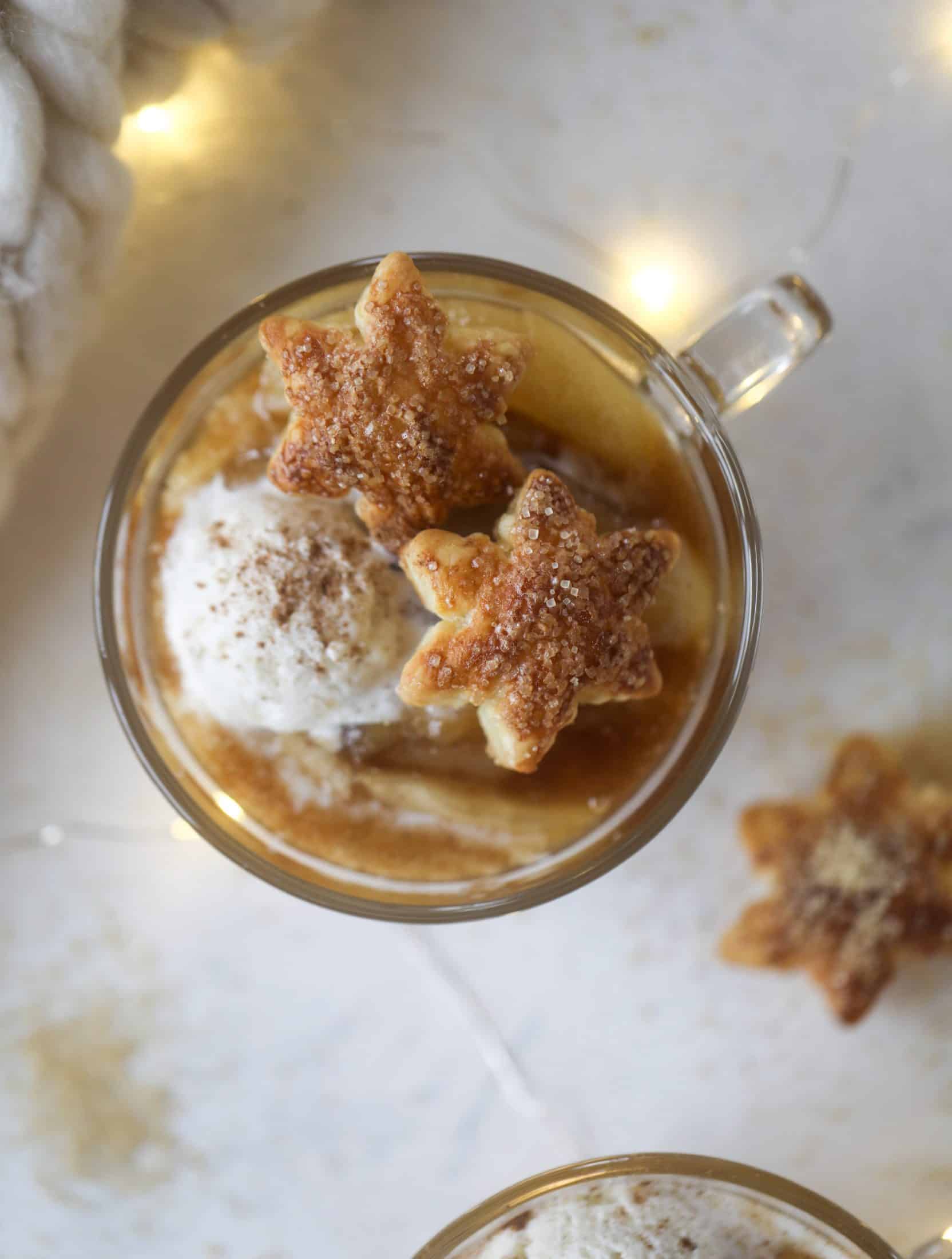 This pear mug pie is the coziest way to enjoy warm, caramelized pears. Topped with vanilla ice cream and the cutest, quick puff pastry stars, these are a great dessert for a dinner party or an easy one to make for yourself on a Saturday night! I howsweeteats.com #pear #mugpie