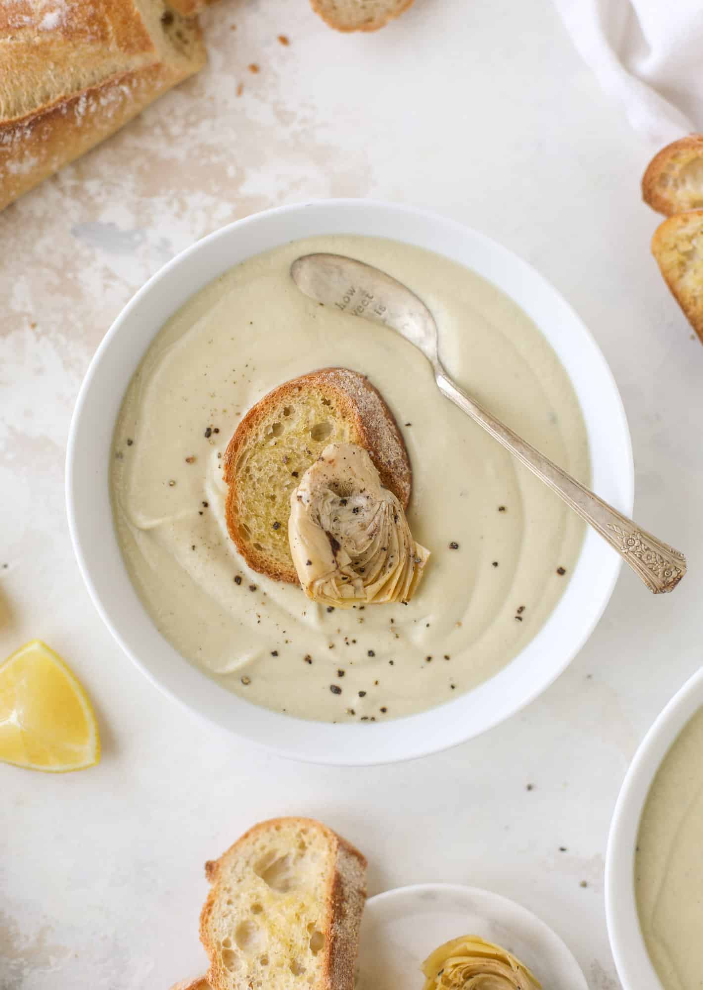 This creamy artichoke soup is full of artichoke hearts, cream and crème fraiche. It's rich and hearty but also light in flavor - perfect for late winter. I howsweeteats.com #artichoke #soup