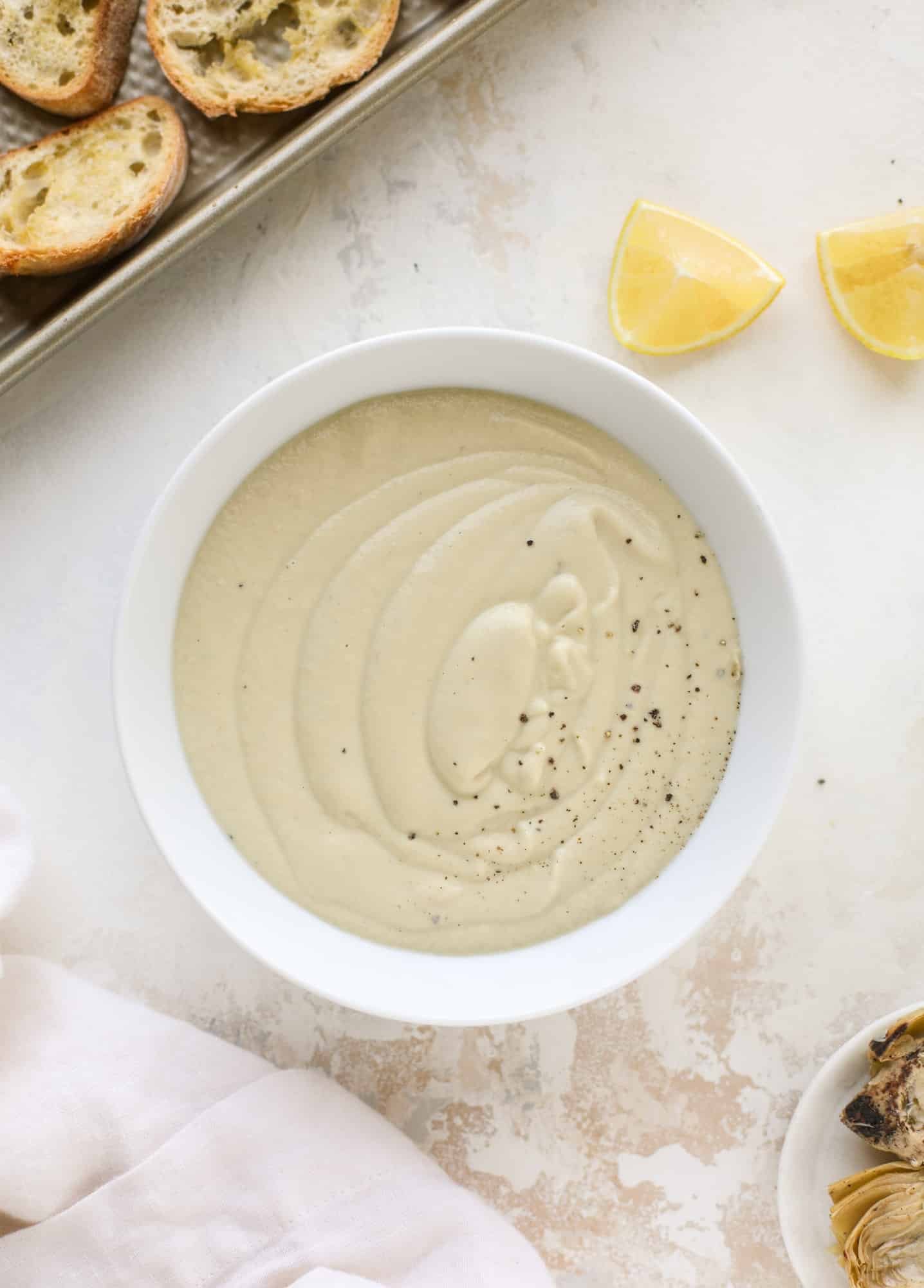 This creamy artichoke soup is full of artichoke hearts, cream and crème fraiche. It's rich and hearty but also light in flavor - perfect for late winter. I howsweeteats.com #artichoke #soup